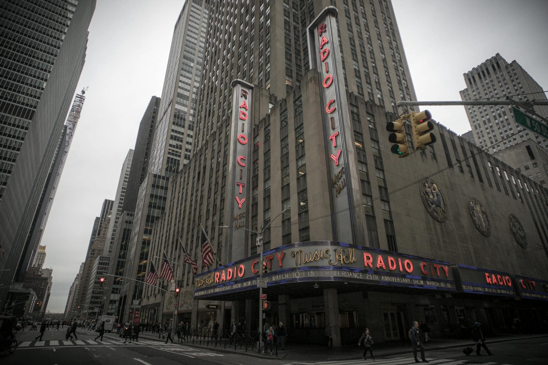 Street view of Radio City Music Hall in Manhattan, New York, featuring urban architecture and bustling city life.
