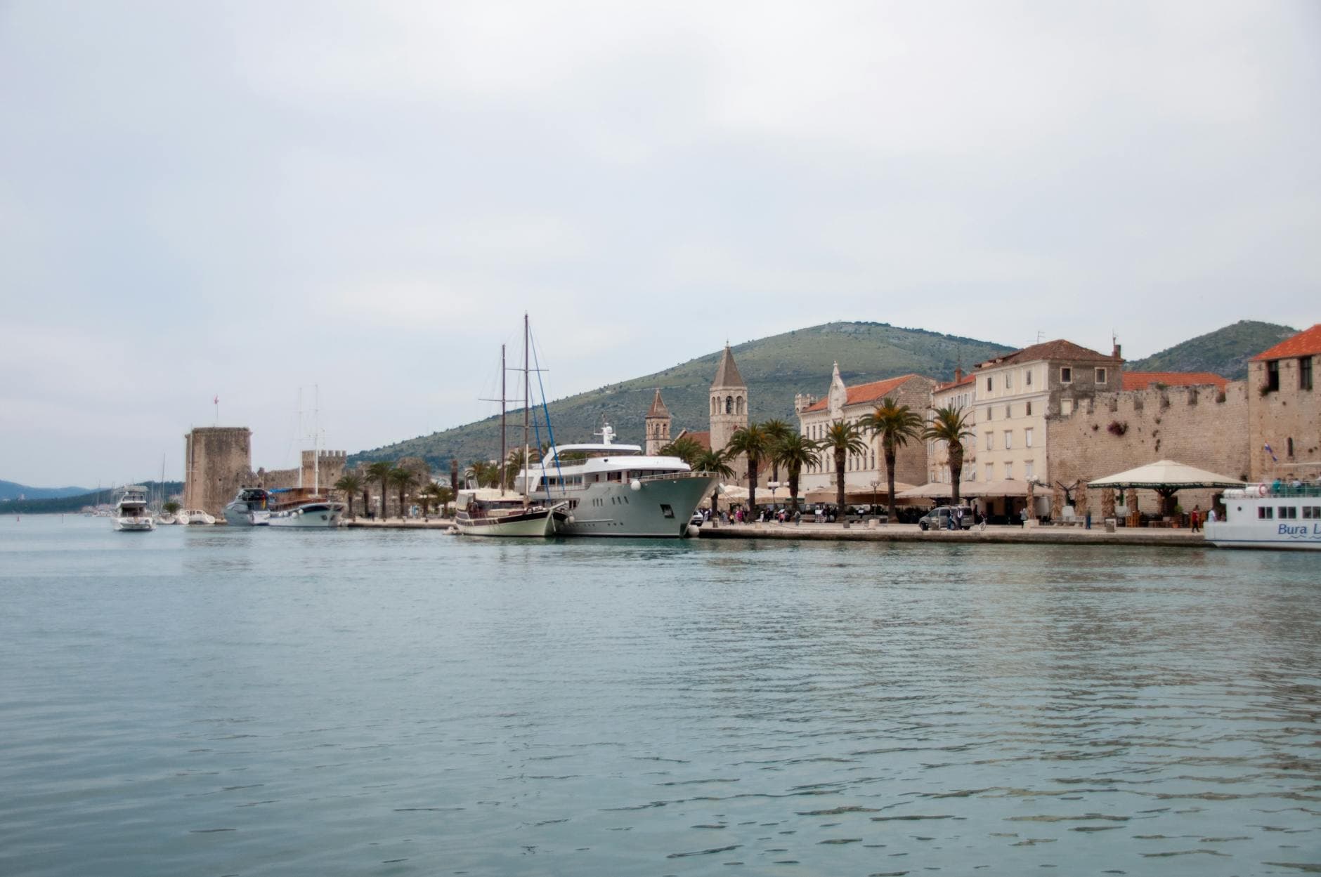 Scenic view of Trogir harbor, Croatia, with boats and historic architecture along the waterfront.
