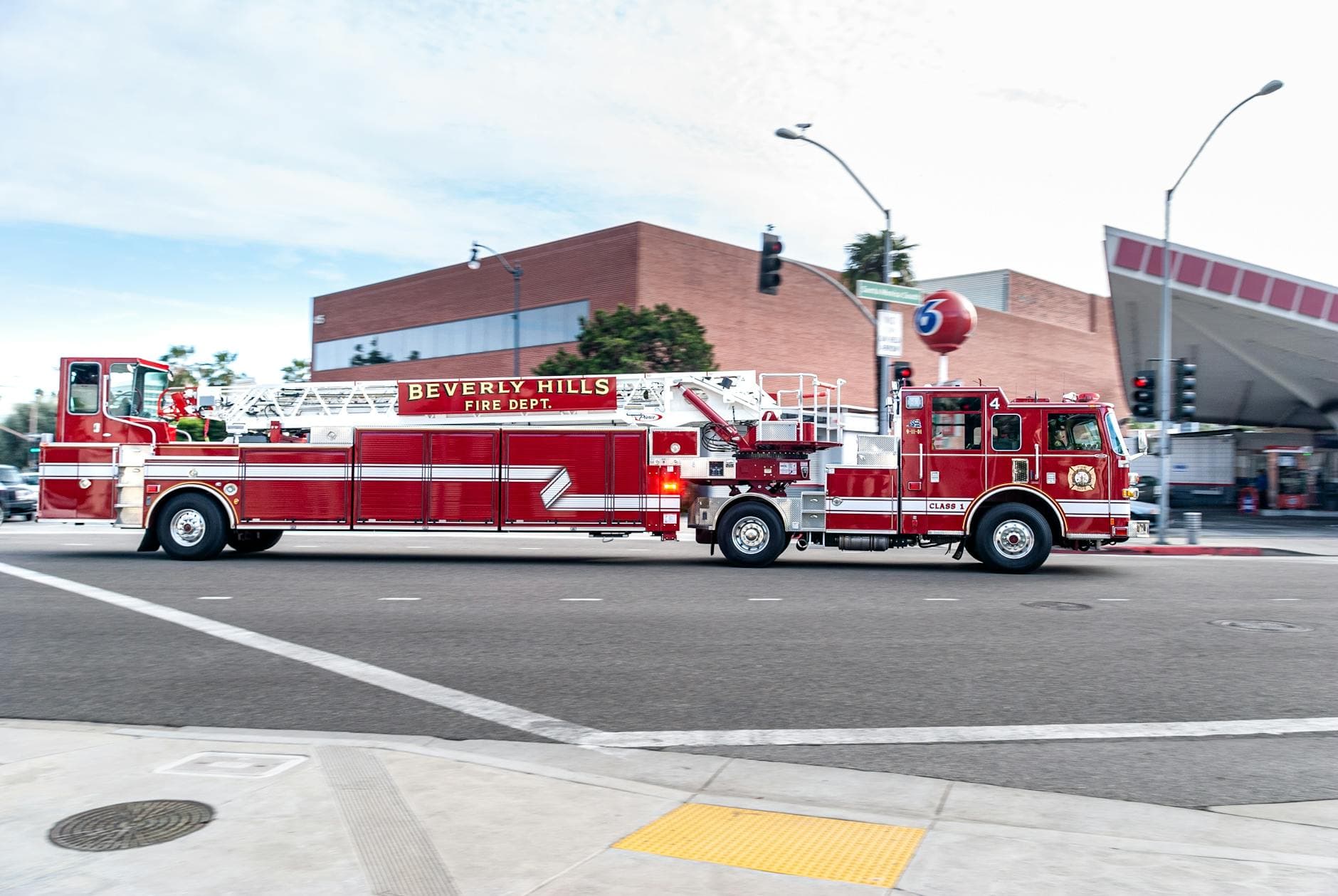 Beverly Hills fire truck driving through a city street, showcasing emergency services in action.