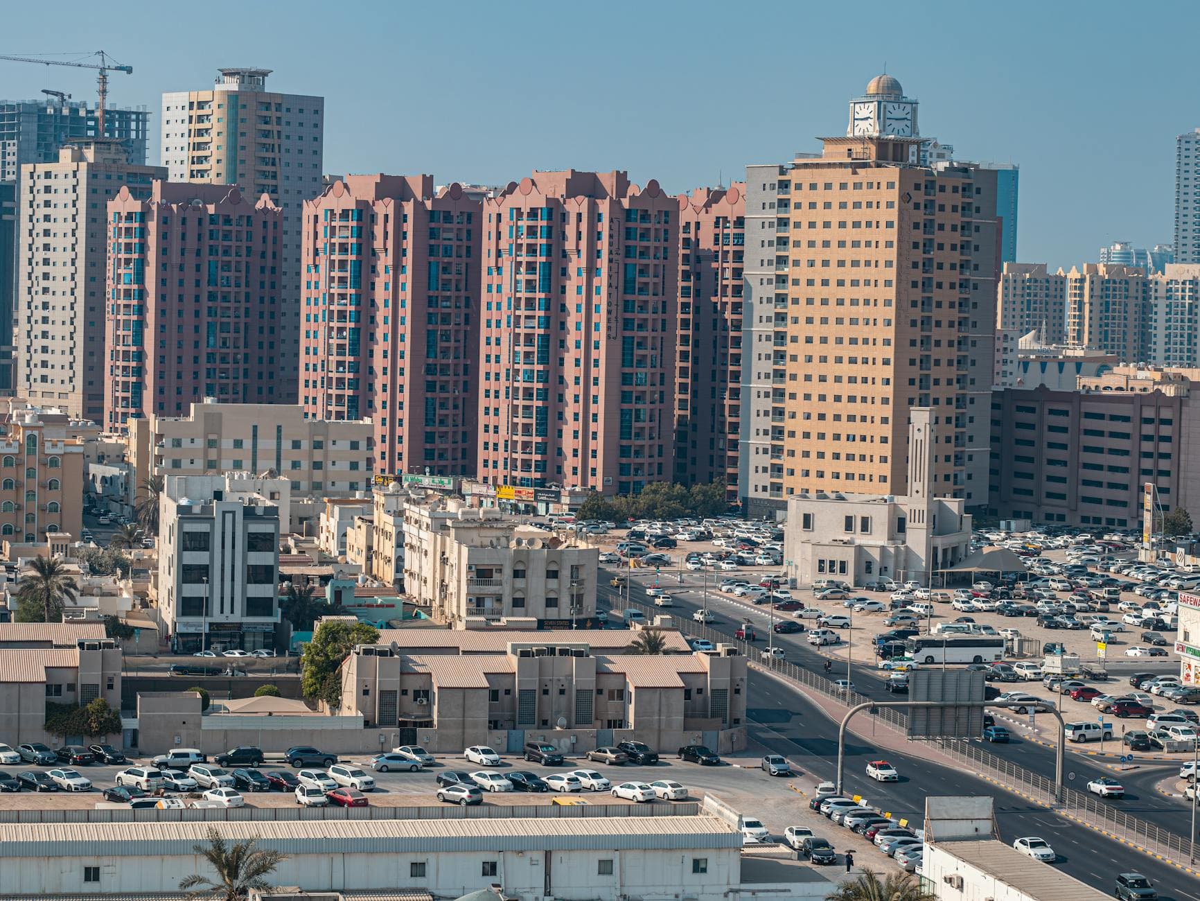 Aerial view of Ajman's skyline featuring tall residential buildings and bustling streets.