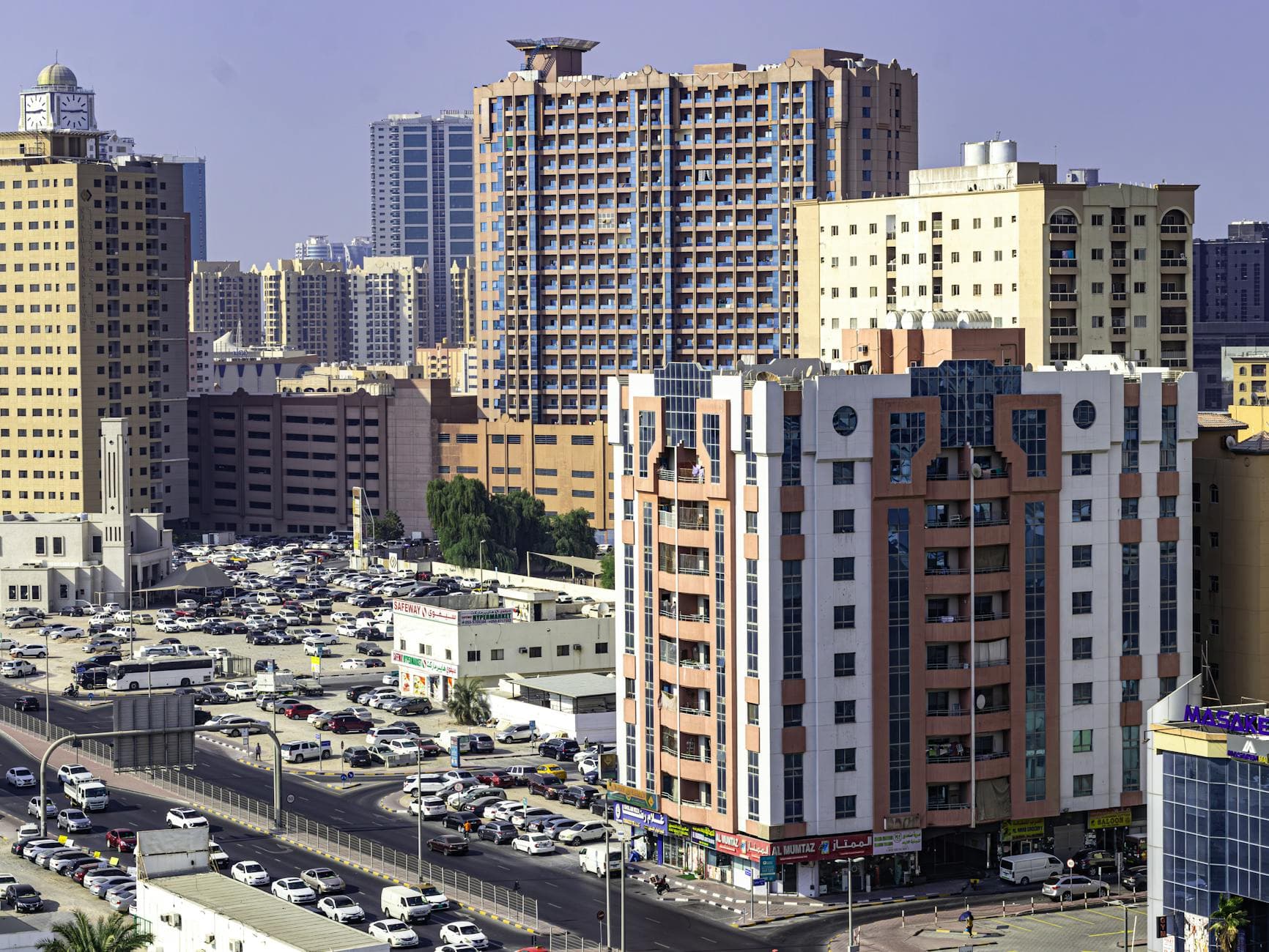 Aerial view of Ajman's urban skyline featuring highrise apartment buildings and busy streets.