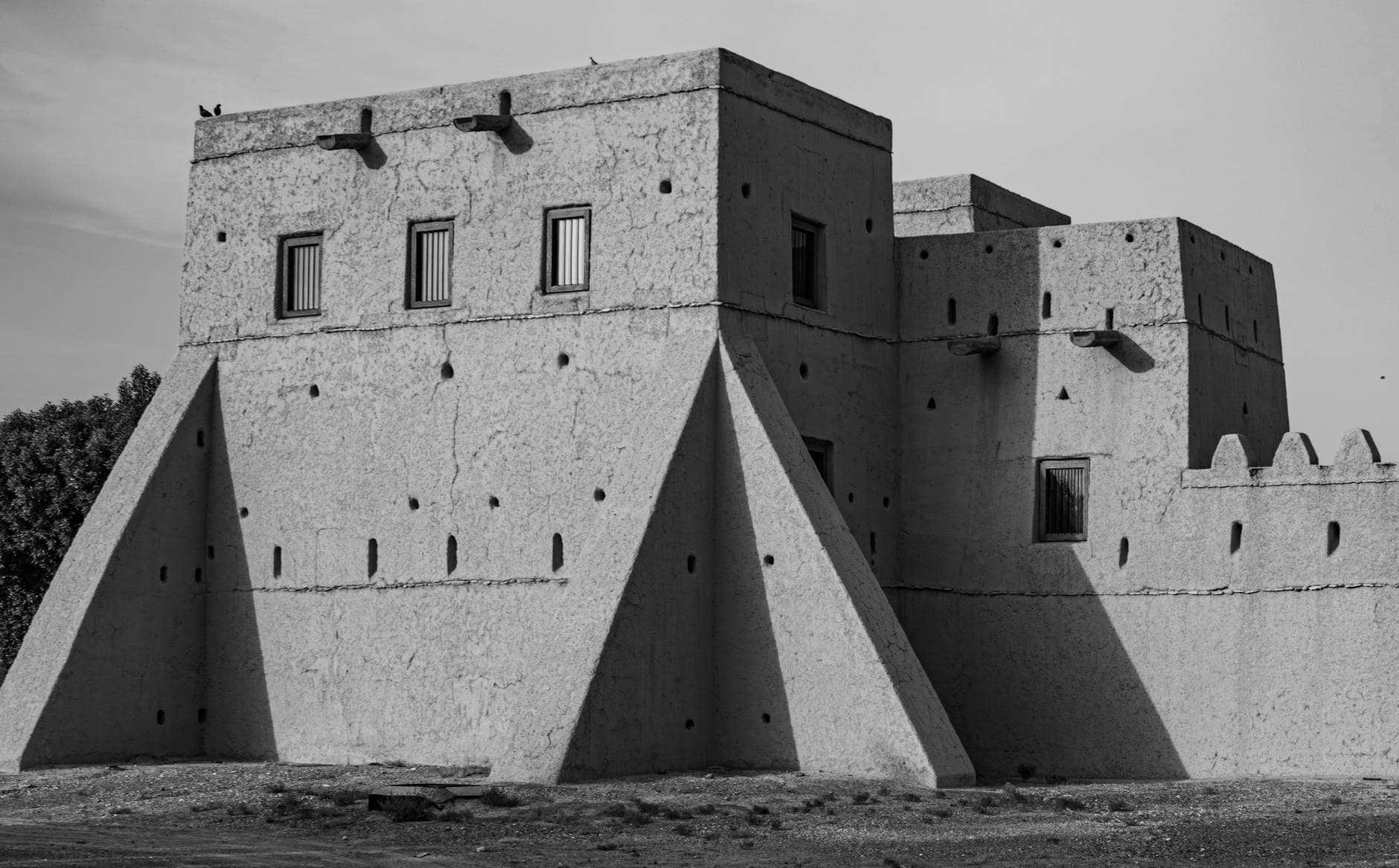 Black and white image of a traditional fort in Al Ain, showcasing architectural heritage of the UAE.