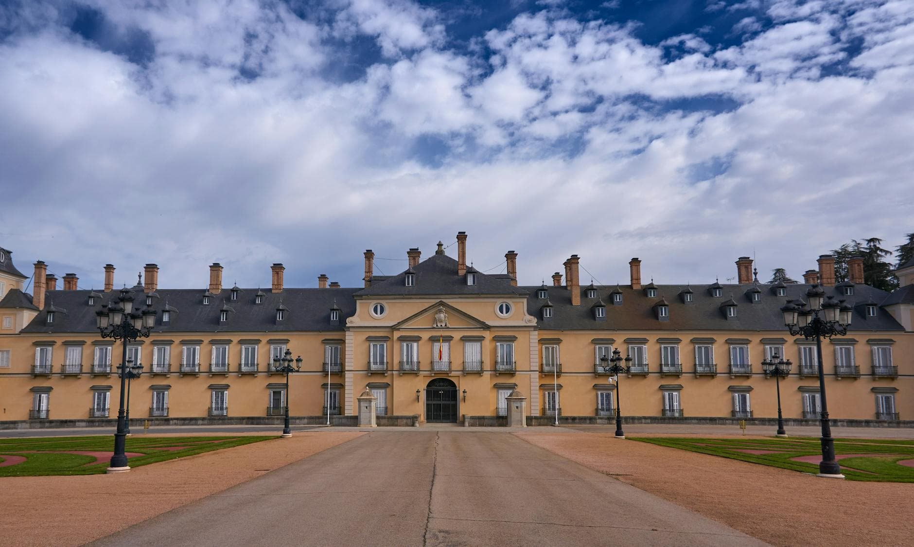 Front view of the historic El Pardo Royal Palace in Madrid, Spain under a cloudy sky.