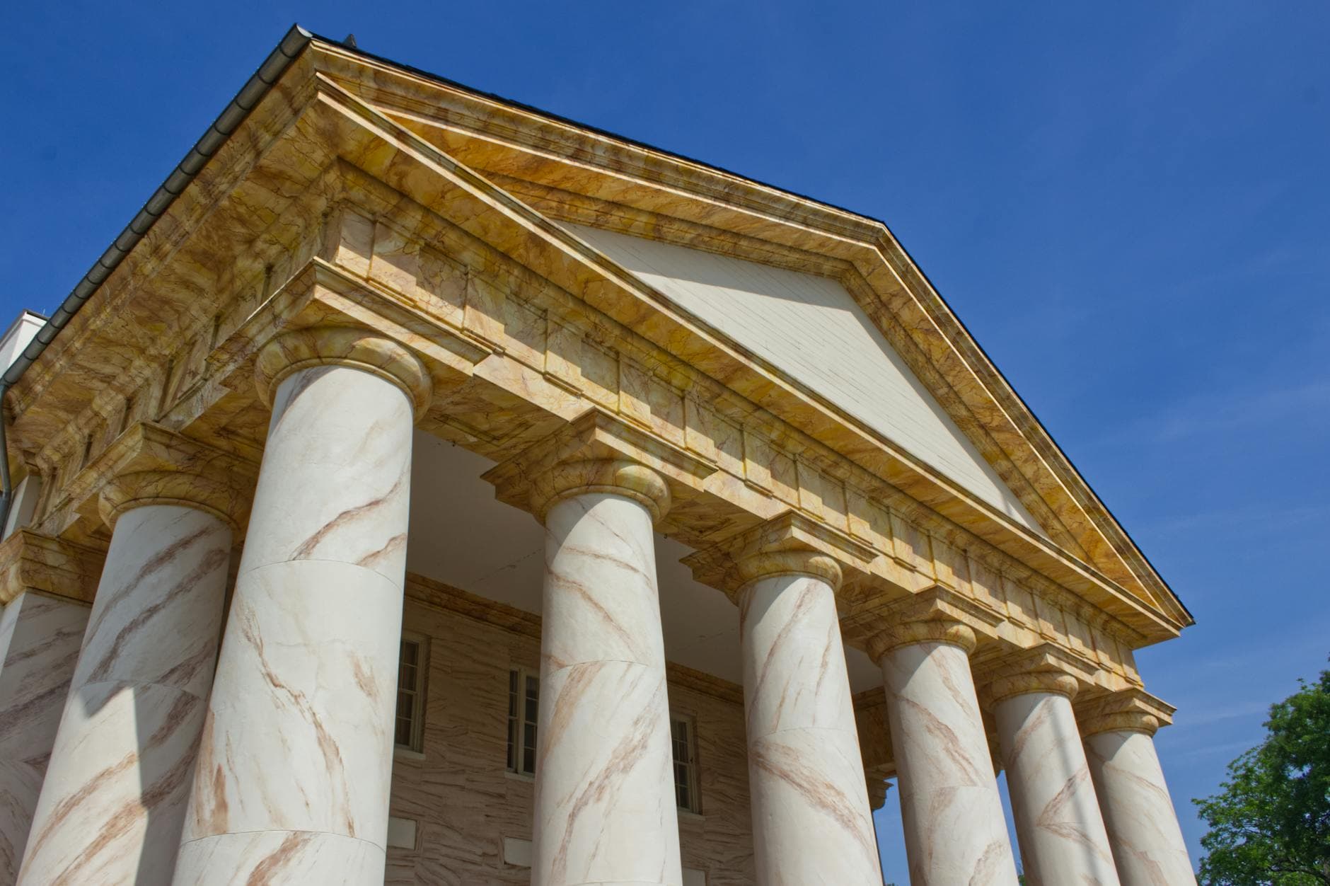 Low angle view of Arlington House showcasing its Greek Revival architecture with grand columns and clear blue sky.