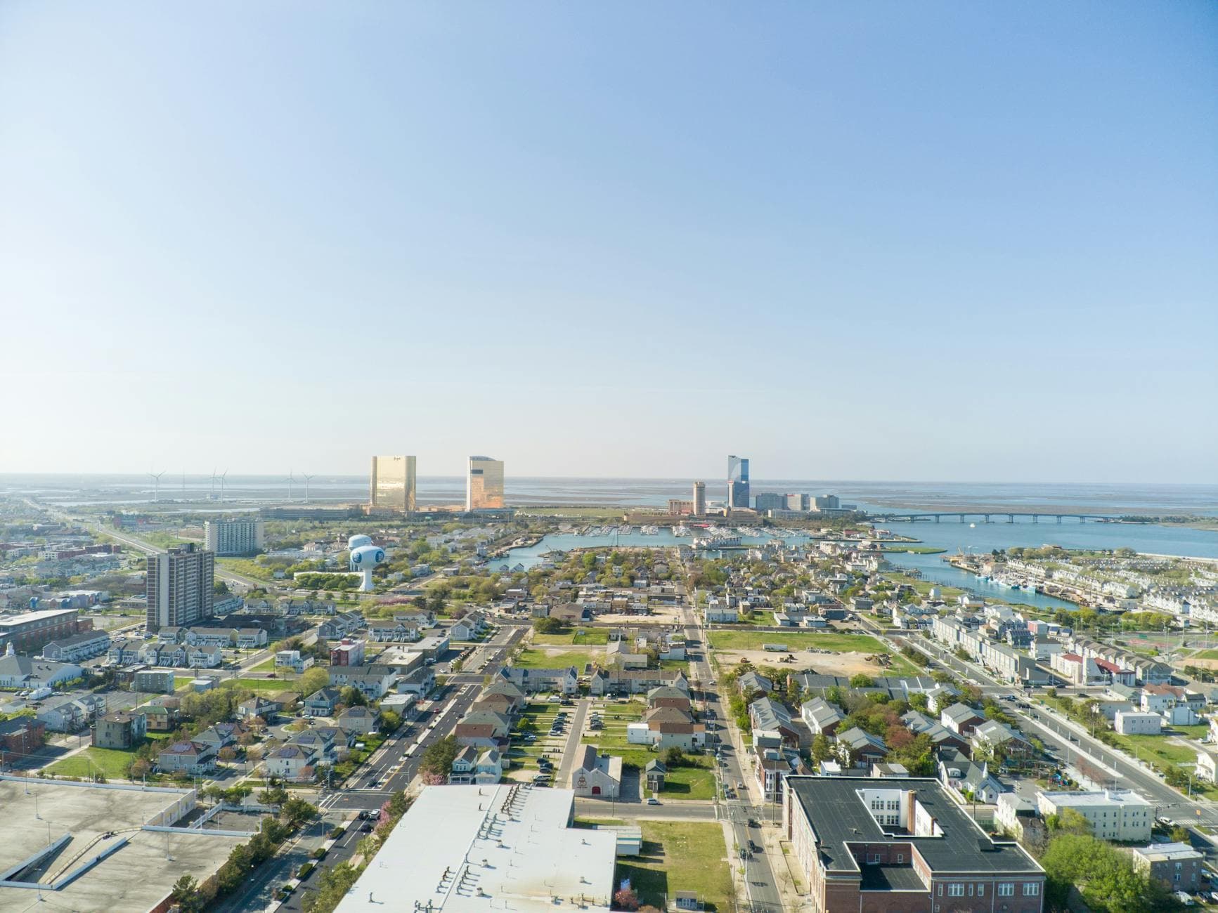 A vibrant aerial shot of Atlantic City, showcasing its bustling cityscape and coastline under clear skies.