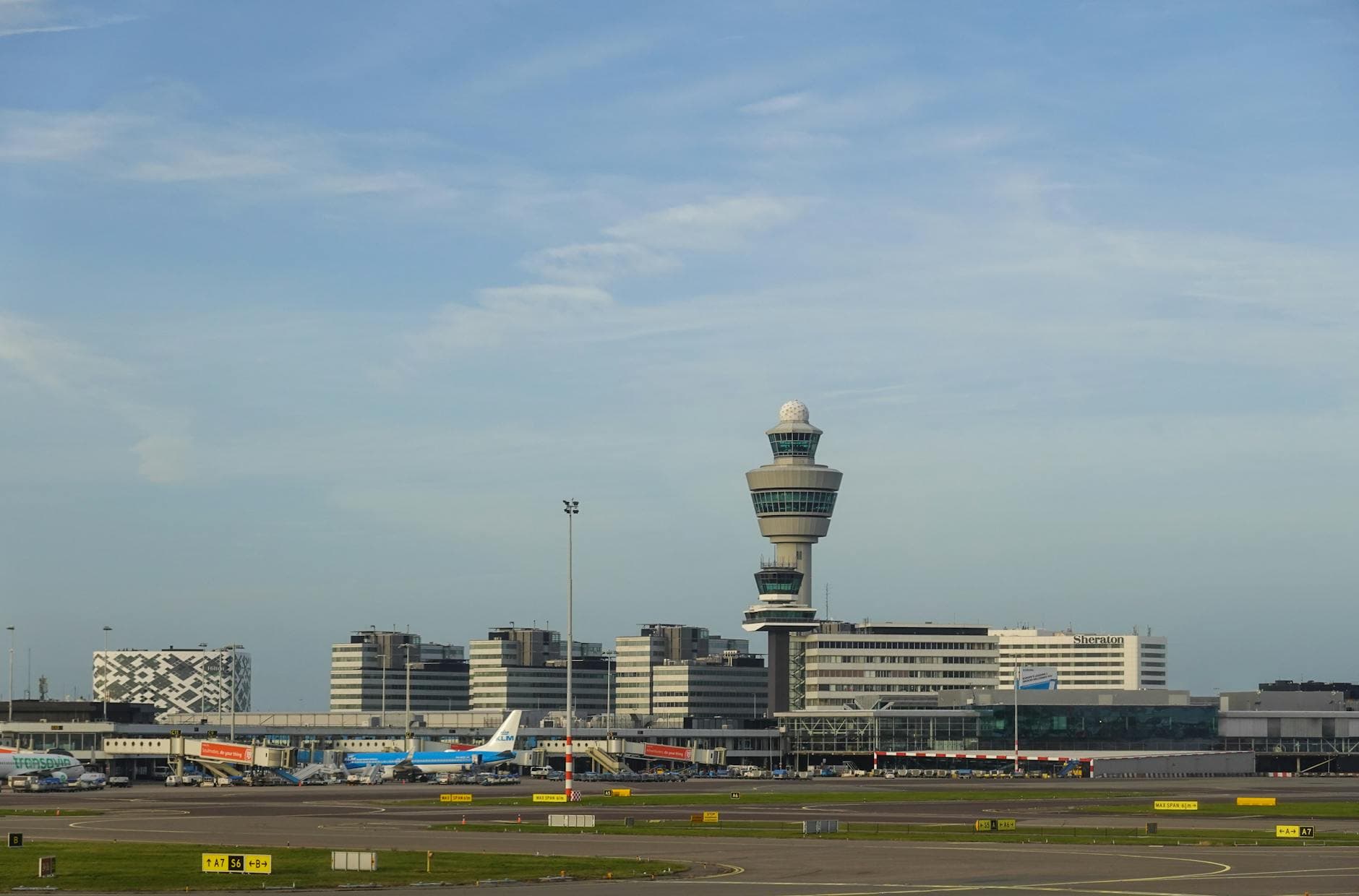 Panoramic view of Amsterdam's Schiphol Airport with control tower on a clear day.