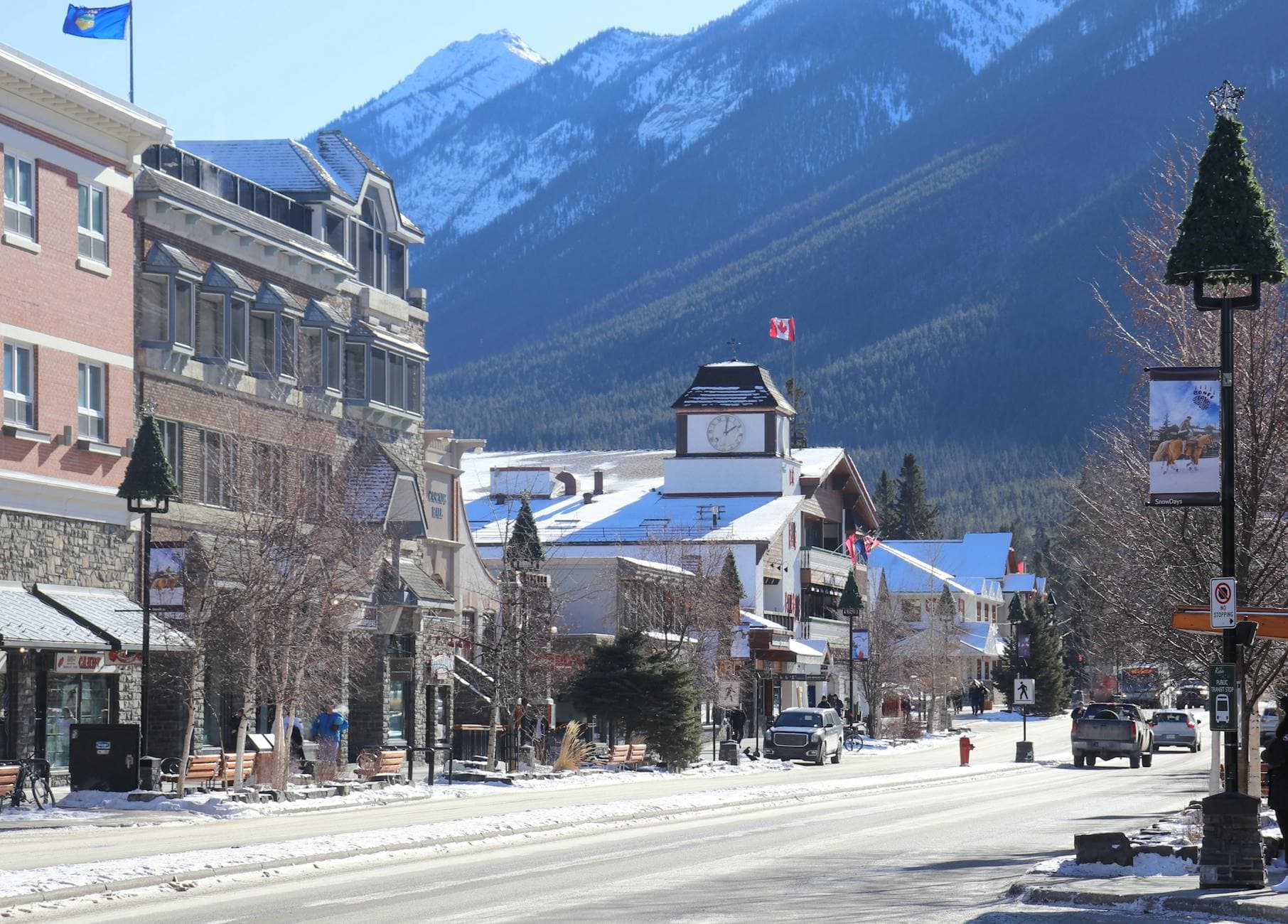 Scenic winter street view with mountain backdrop in Banff, Alberta, Canada.
