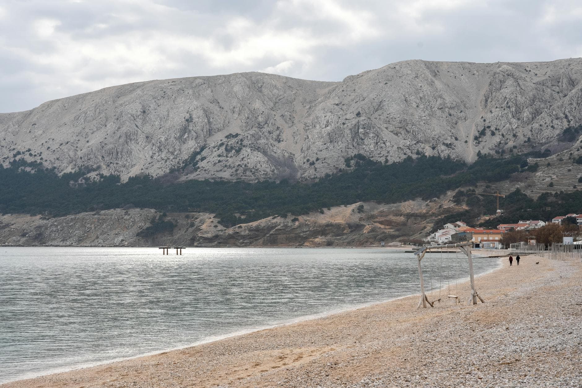 Explore the tranquil beauty of Baska Beach in Krk, Croatia, with mountains and coastal scenery.