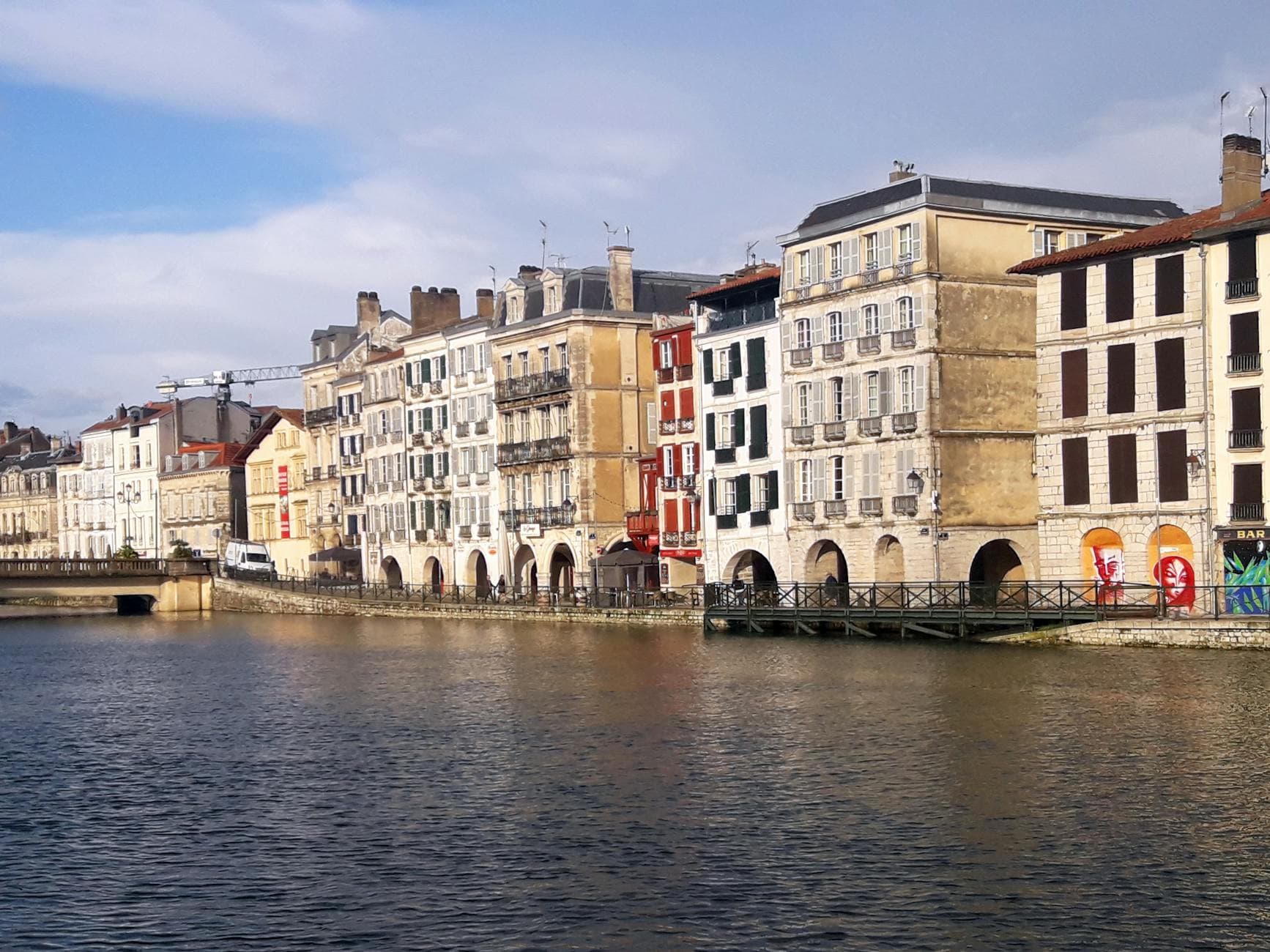 Picturesque view of historical buildings along the Nive River in Bayonne, France, showcasing vibrant urban architecture.