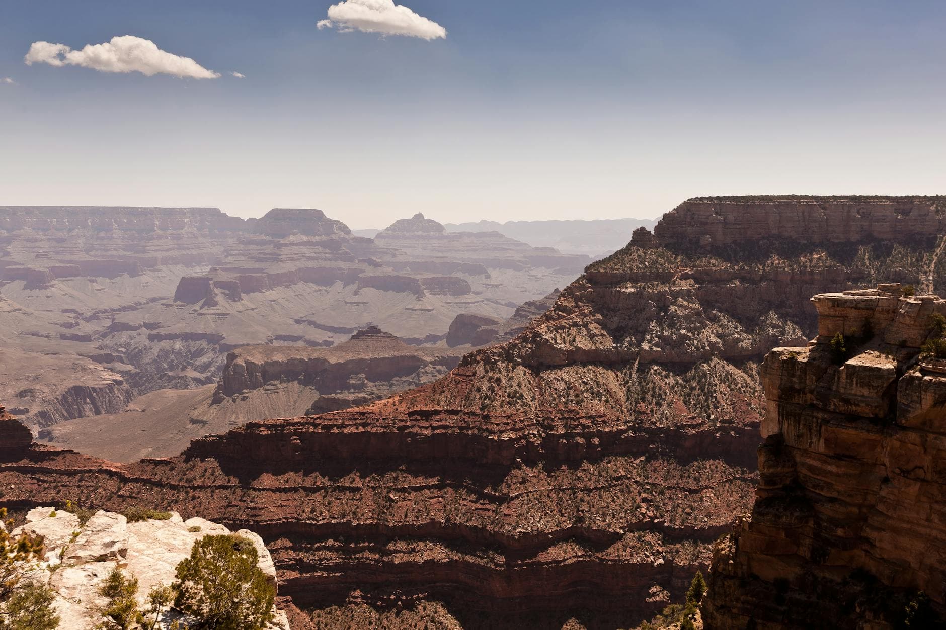 Expansive view of the Grand Canyon's rugged terrain under a clear sky.