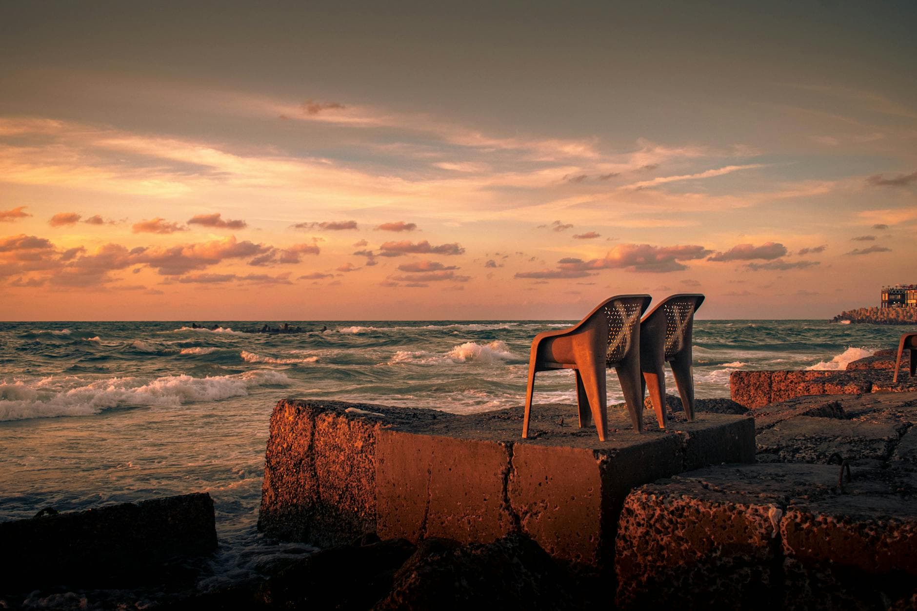 Two chairs overlooking the scenic sunset at Alexandria beach, Egypt.