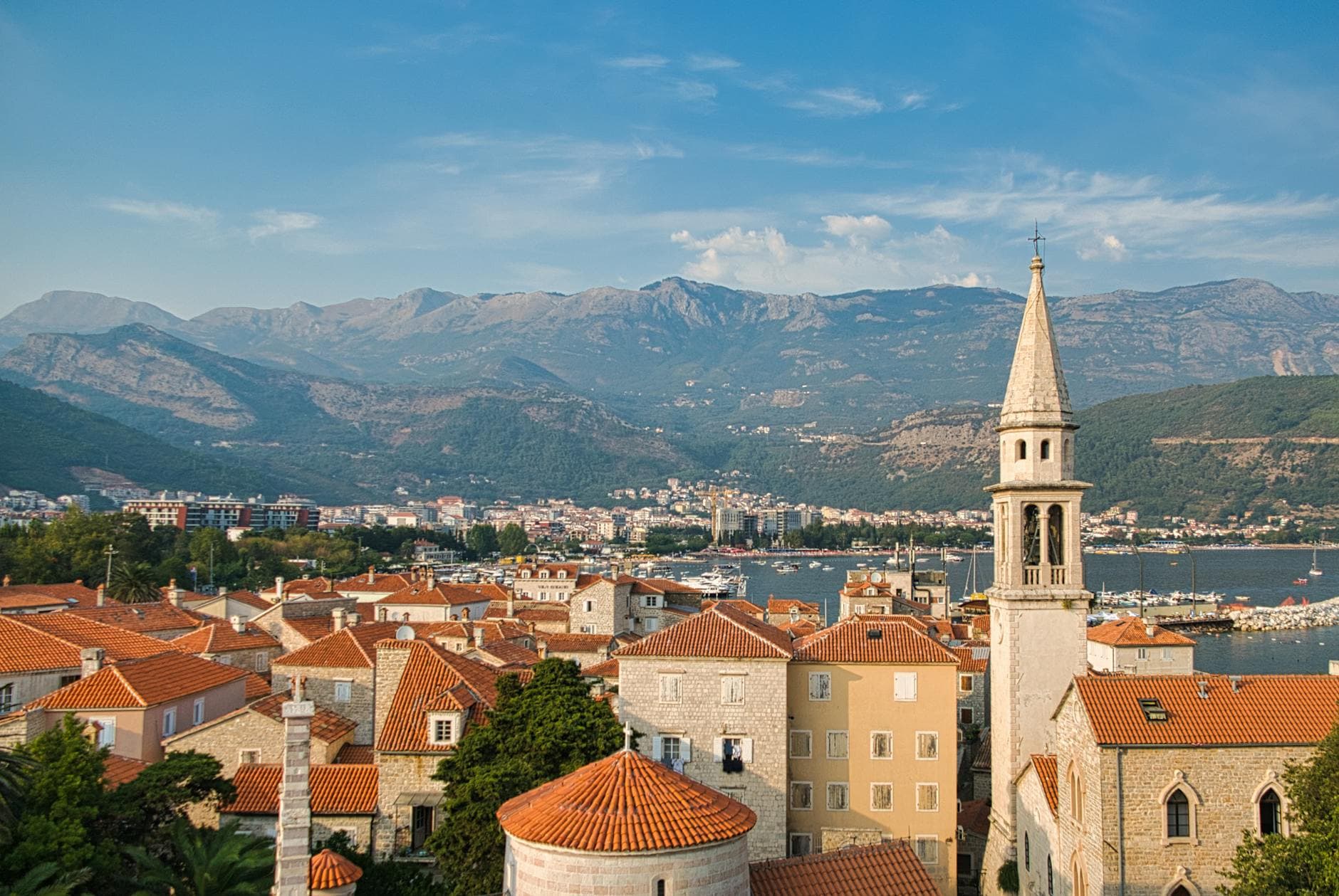 Explore the stunning coastal town of Budva, Montenegro, with its historic architecture and mountain backdrop.