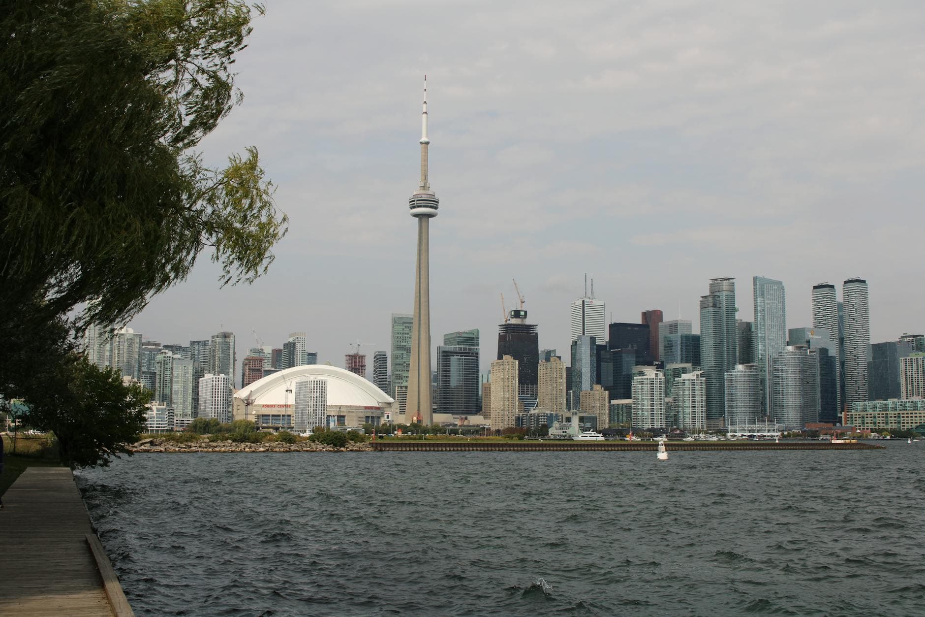 Capture of Toronto's iconic skyline featuring the CN Tower and waterfront on a calm day.