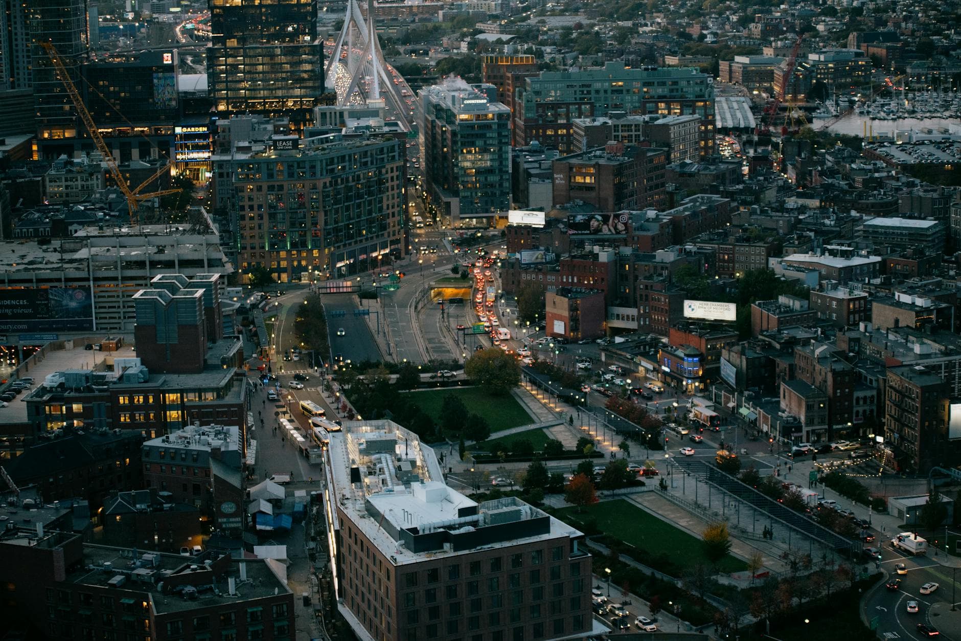 Stunning aerial view of Boston's cityscape at dusk, featuring modern architecture and urban streets.