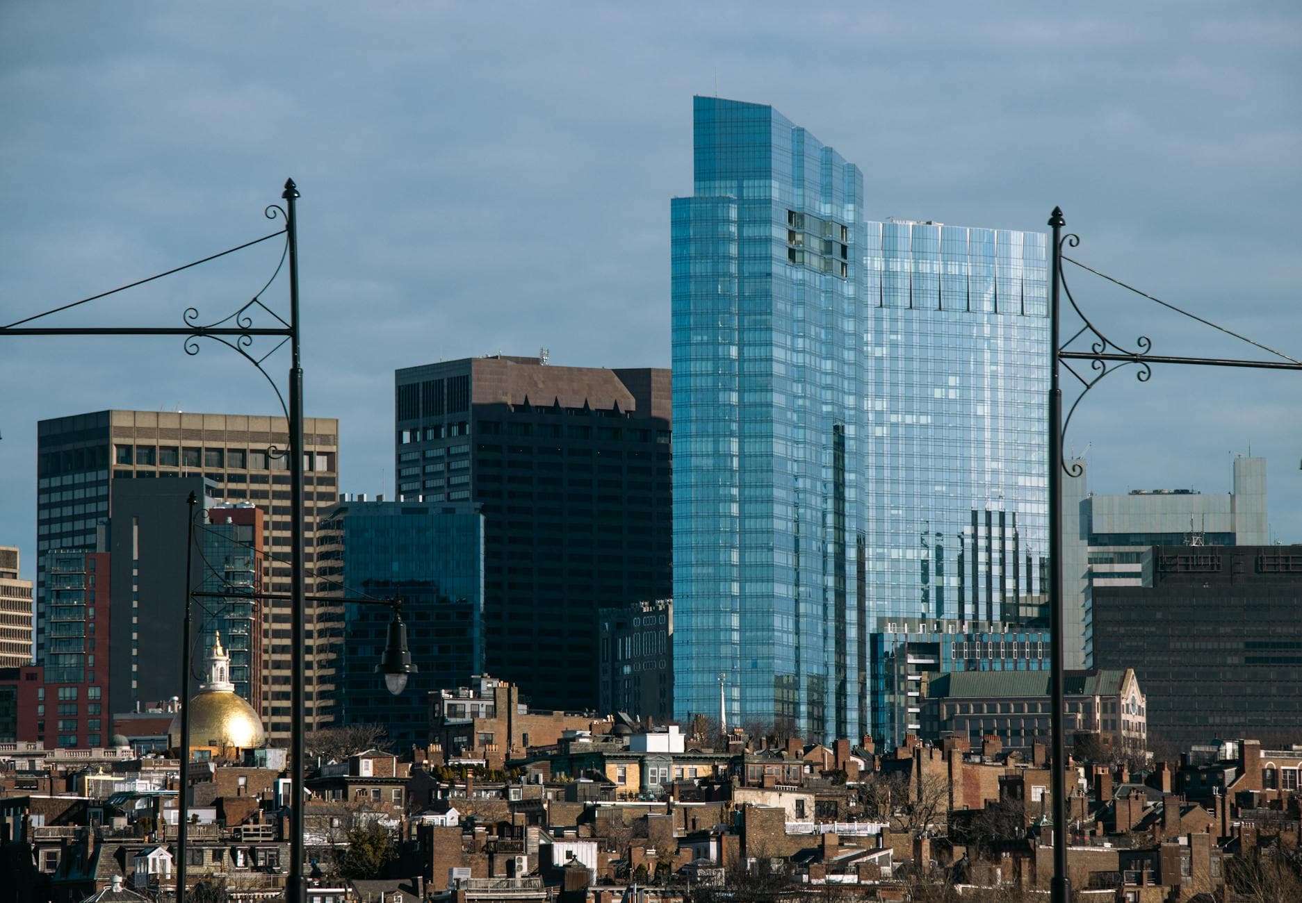 A dynamic view of Boston's skyline showcasing modern skyscrapers and historic buildings under a clear sky.