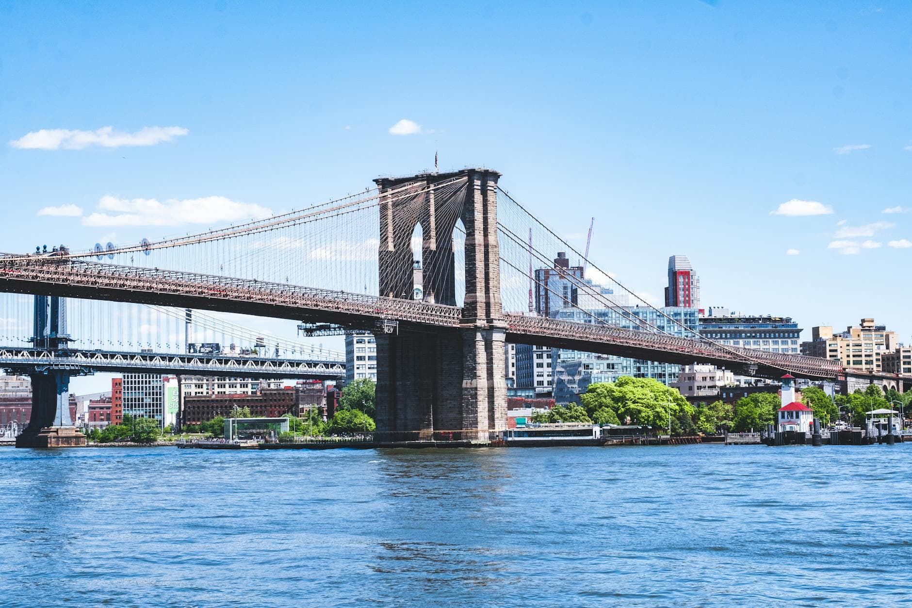 Scenic view of the Brooklyn Bridge over the East River in New York City during a sunny day.