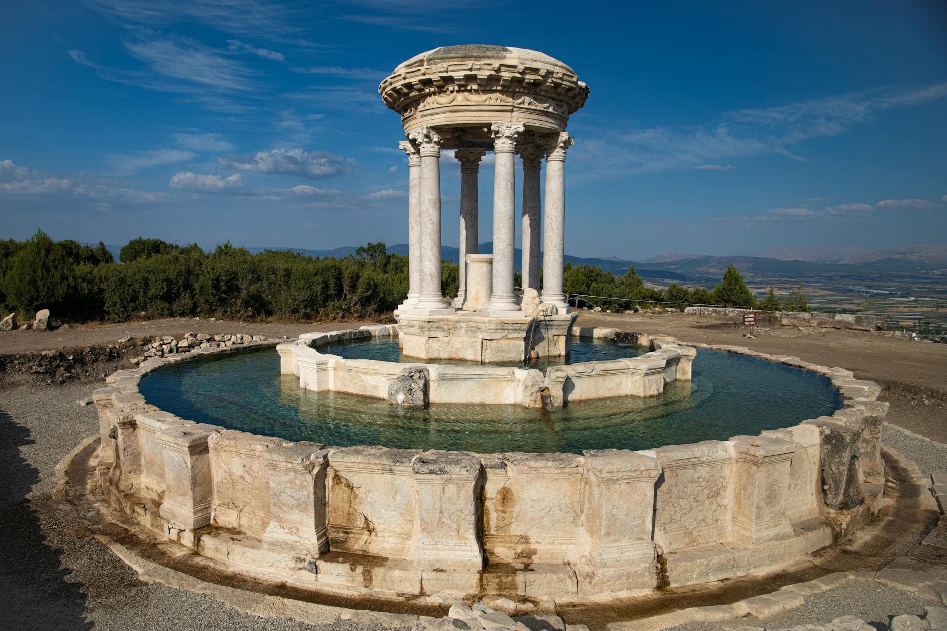 Stunning view of ancient ruins with a historic circular fountain in Turkey.