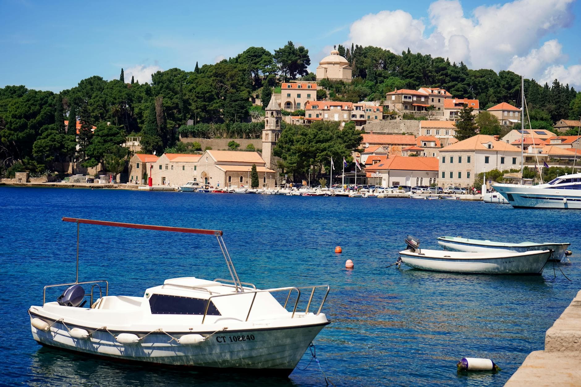 Idyllic scene of Cavtat harbor with boats and historic architecture in Croatia.