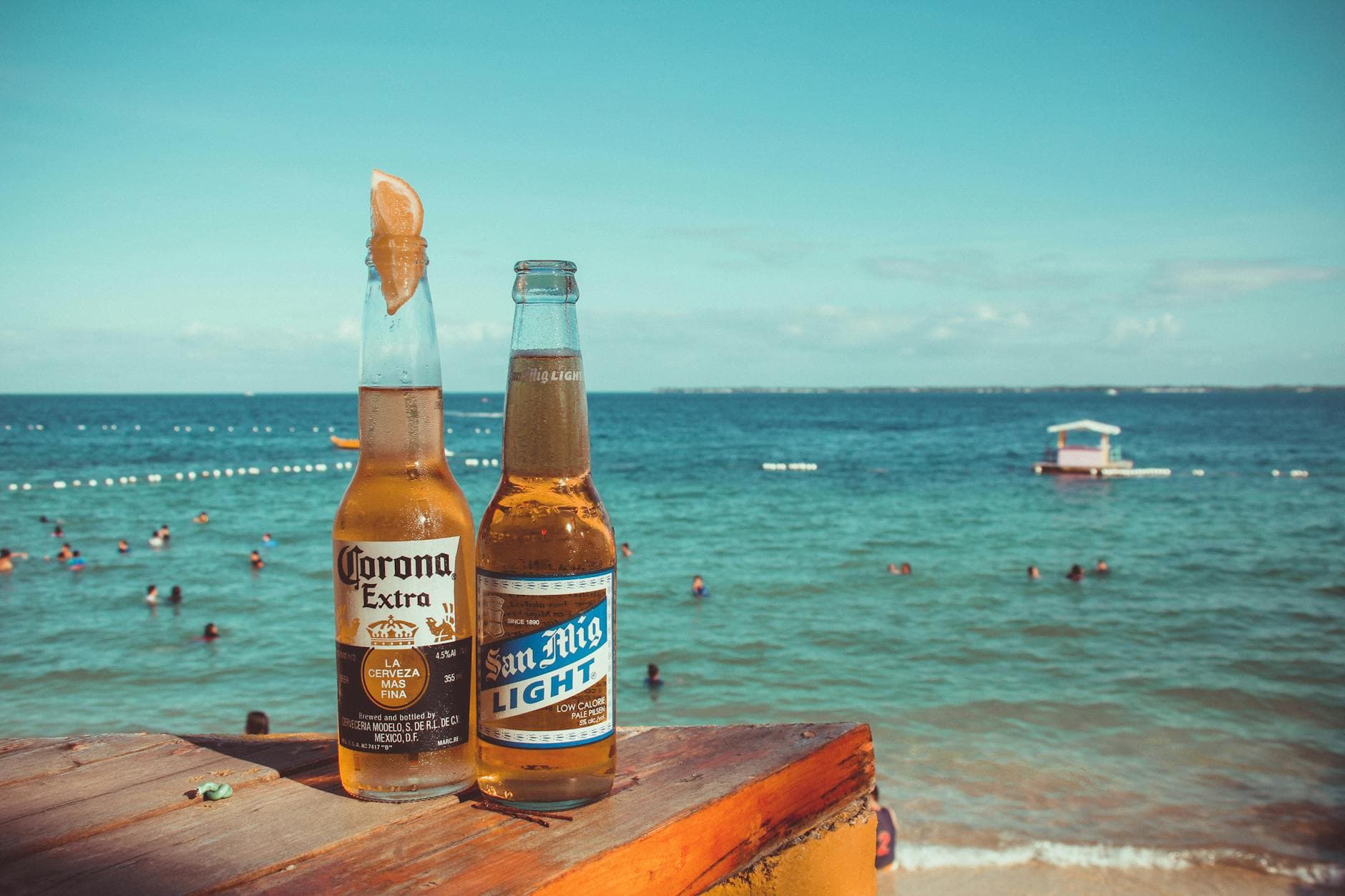 Two cold beers on a table overlooking a tropical beach in Lapu-Lapu City, Philippines.