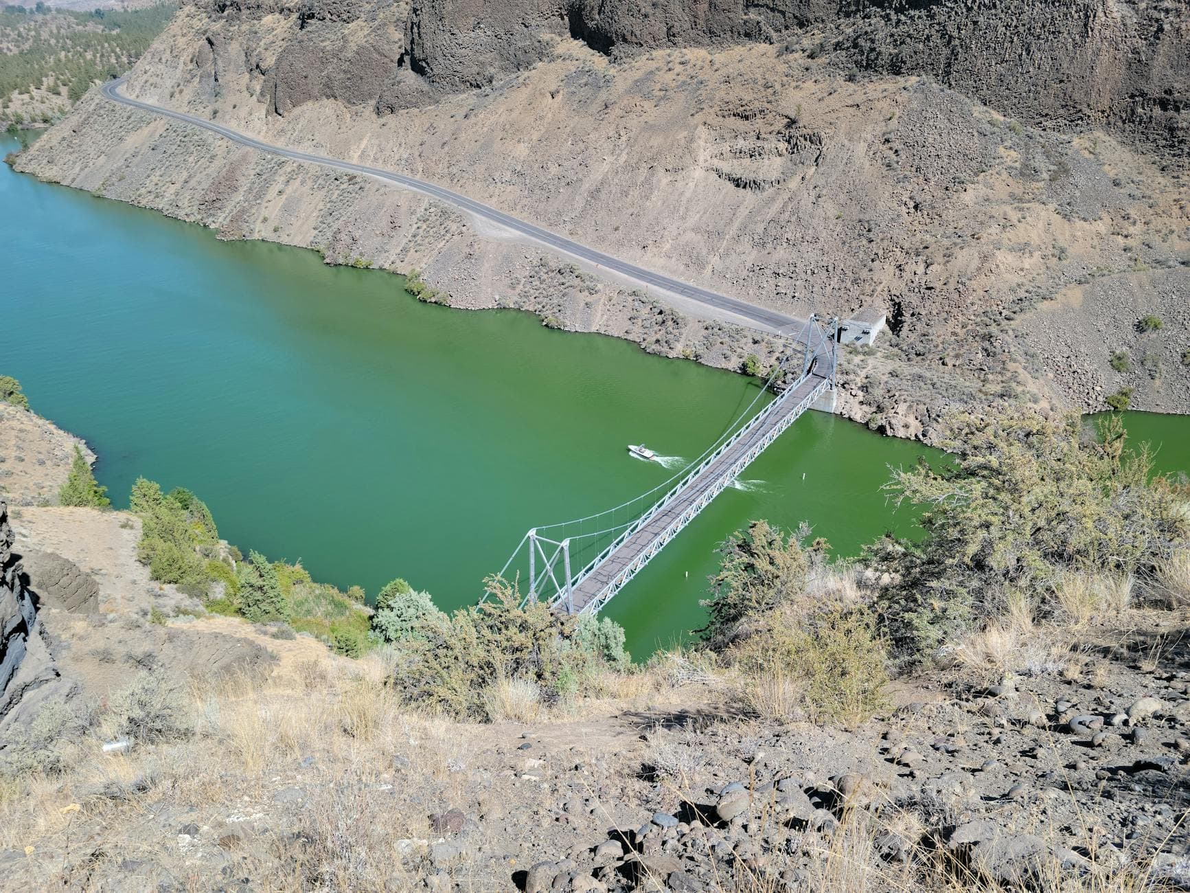 A beautiful aerial view of a bridge spanning the green waters of Culver Reservoir in Oregon, USA.