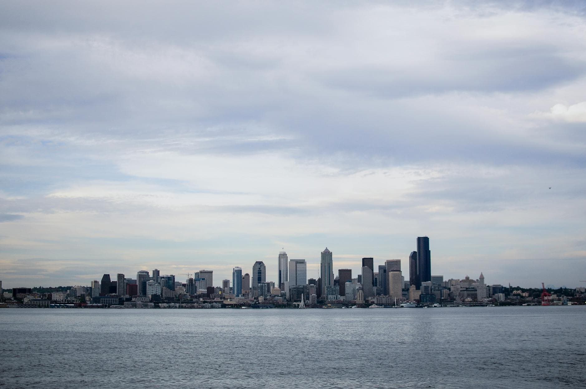 A panoramic view of the Seattle skyline from across the water on an overcast day.