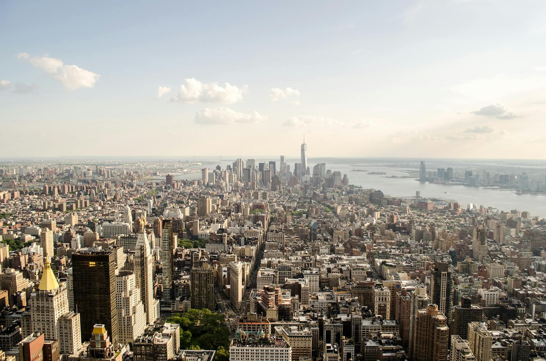 A breathtaking aerial view of New York City showcasing the iconic skyline over the river under a clear sky.
