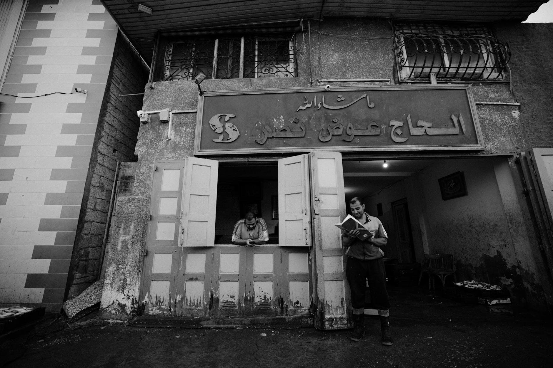 Black and white capture of a street scene in Damietta, Egypt, featuring local workers.