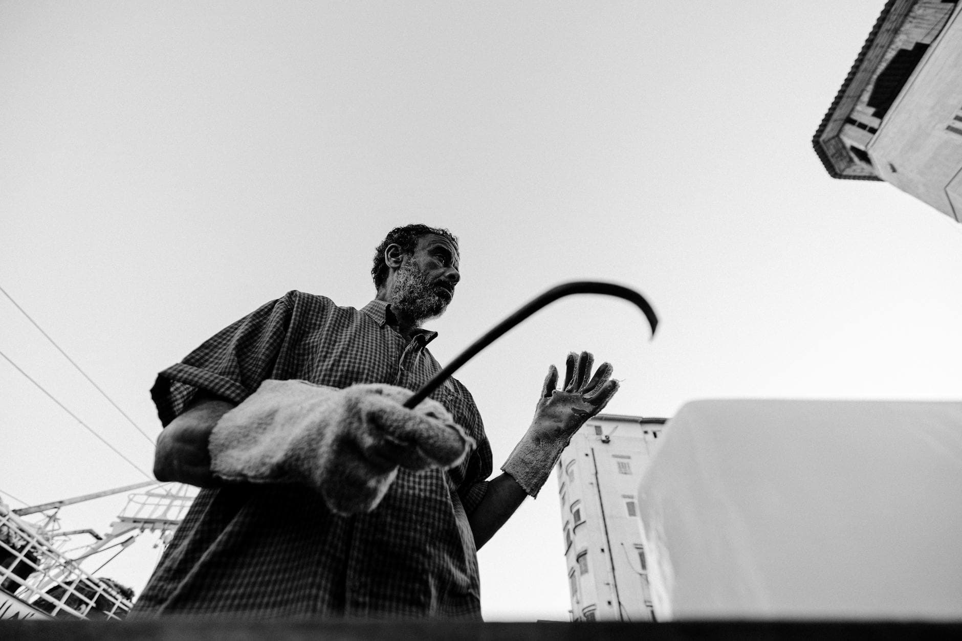 A fisherman in Damietta, Egypt, captured in a dramatic black and white street photograph.