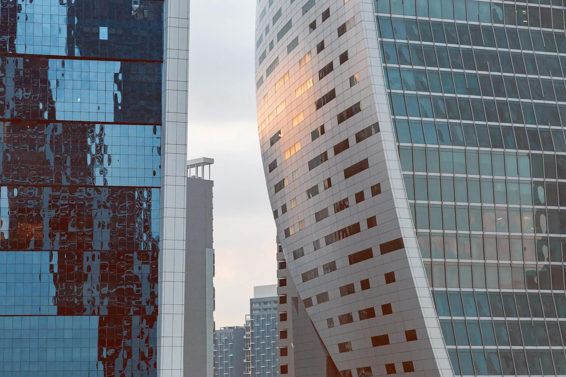 View of futuristic skyscrapers with glass facades in Dubai, reflecting a vibrant urban scene.