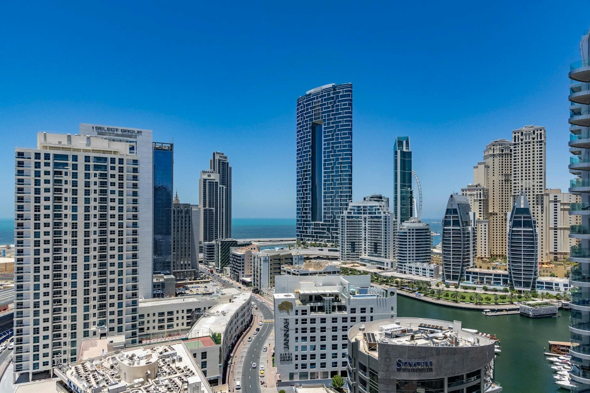 Stunning view of Dubai Marina's iconic skyscrapers and waterfront under a clear blue sky.