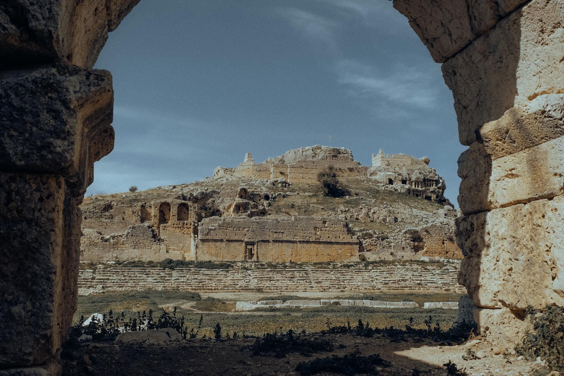 A breathtaking view of the ancient ruins of Tlos in Fethiye, Turkey, framed by stone arches.