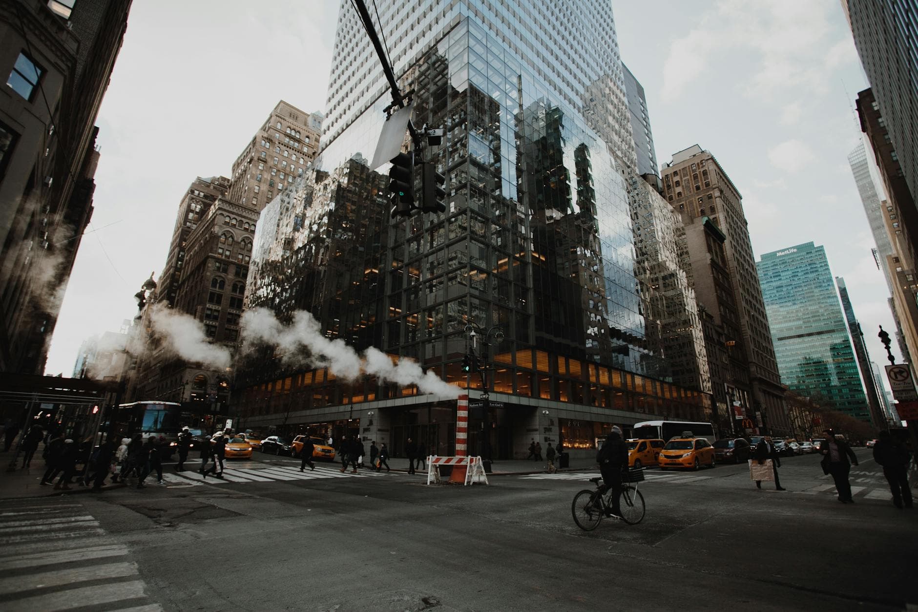 View of a busy intersection in New York City with skyscrapers and traffic.