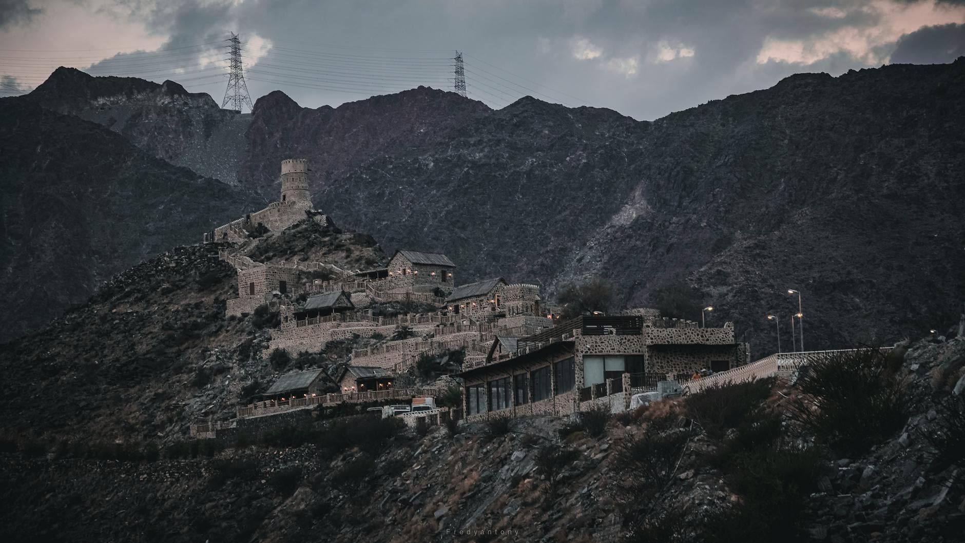 A captivating view of an ancient stone fortress nestled in the rugged mountains of Fujairah, UAE.