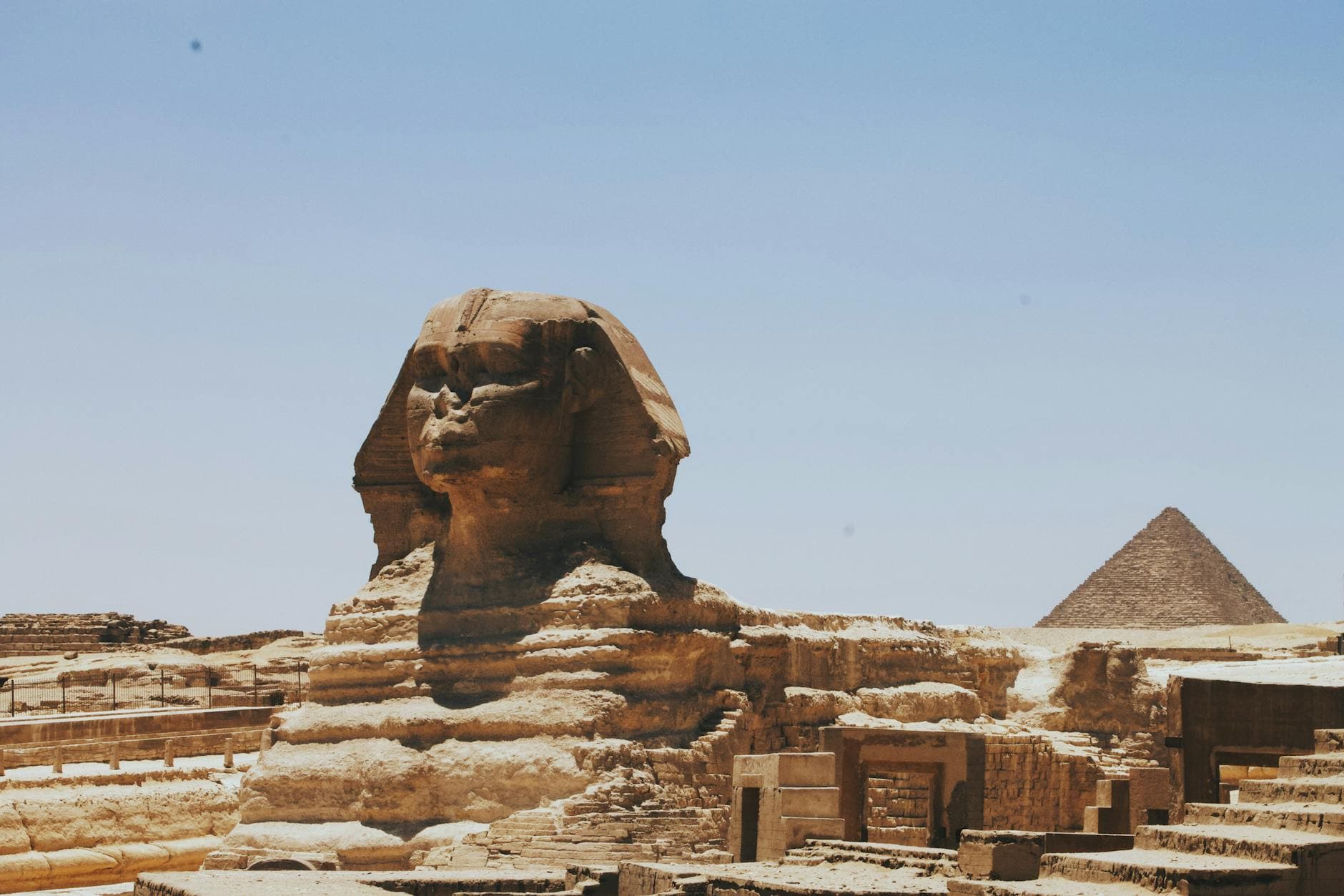 View of the Great Sphinx of Giza and Pyramid, iconic Egyptian landmarks in daylight.