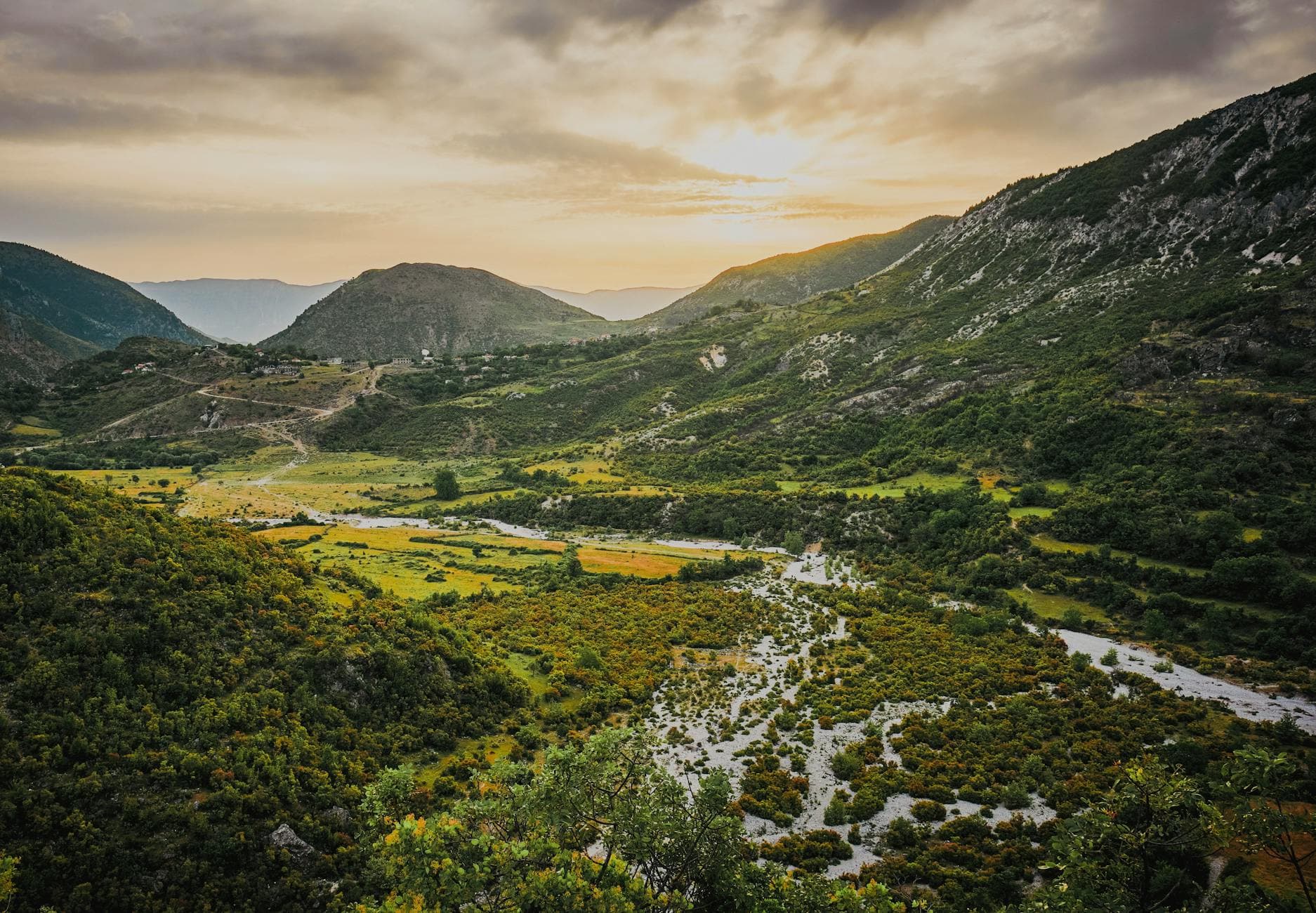 A breathtaking aerial view of Zhulat's lush mountains during sunset in Gjirokastër County, Albania.