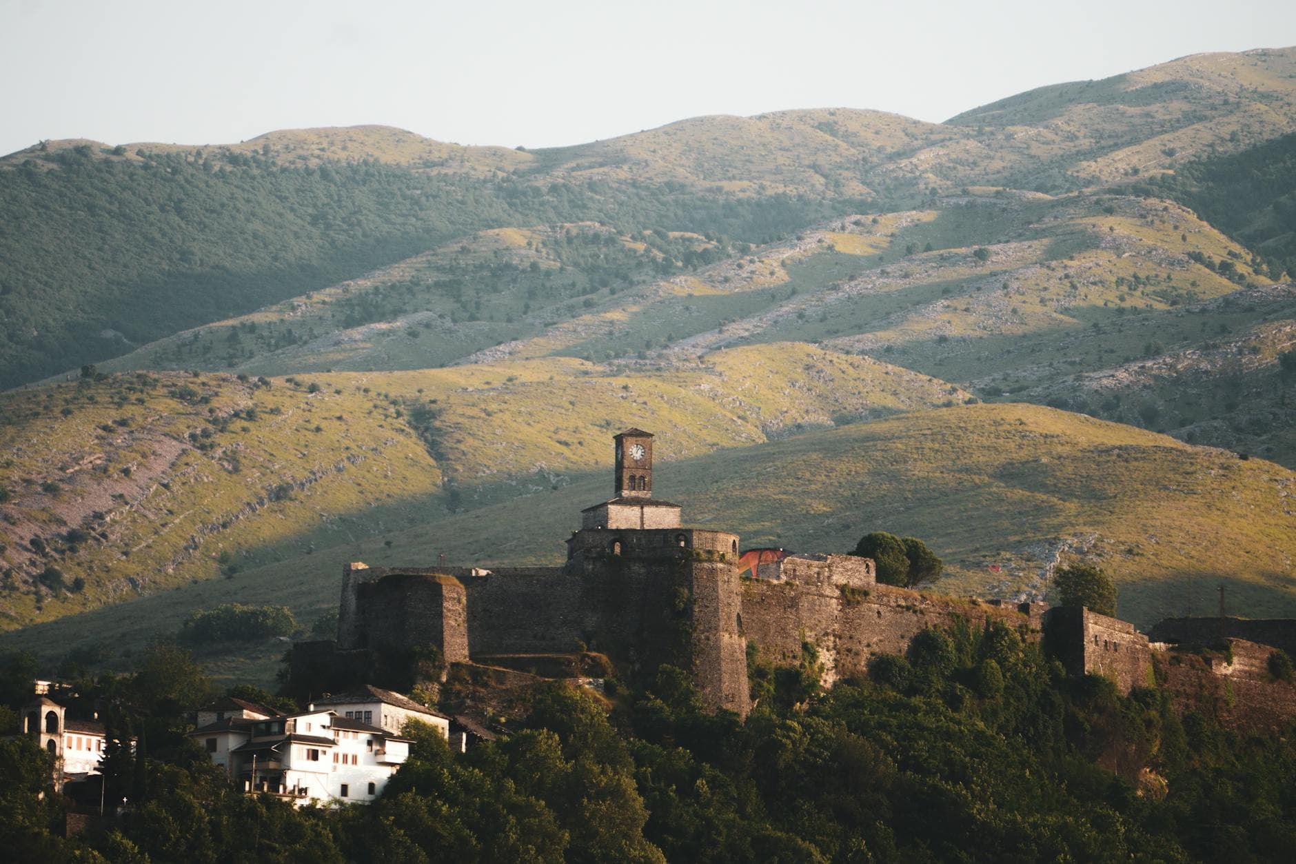 Aerial view of Gjirokaster Fortress amidst lush green hills in Albania