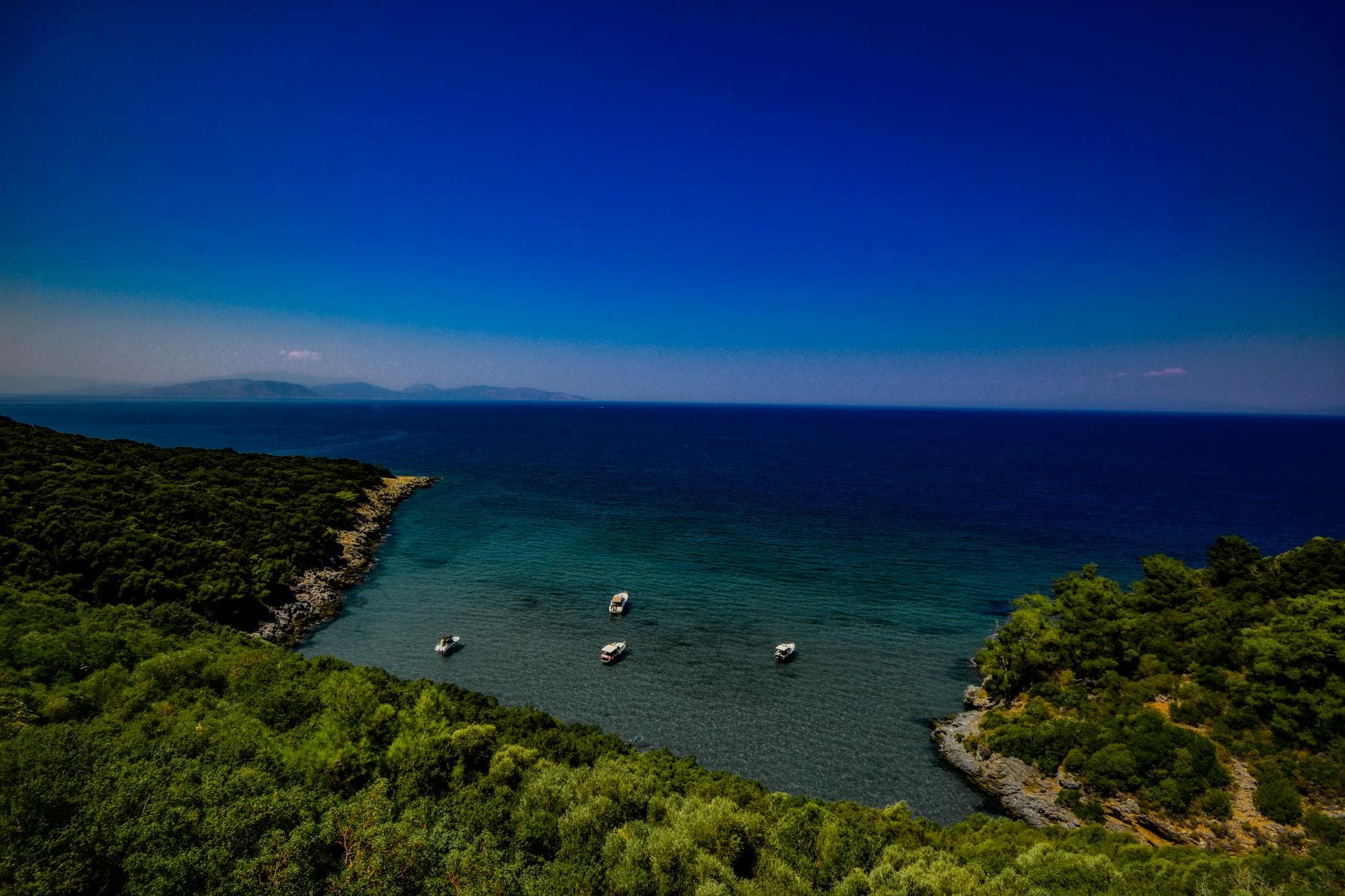 A stunning aerial view of the coastline at Güzelçamlı, Türkiye, featuring lush greenery and clear blue waters.