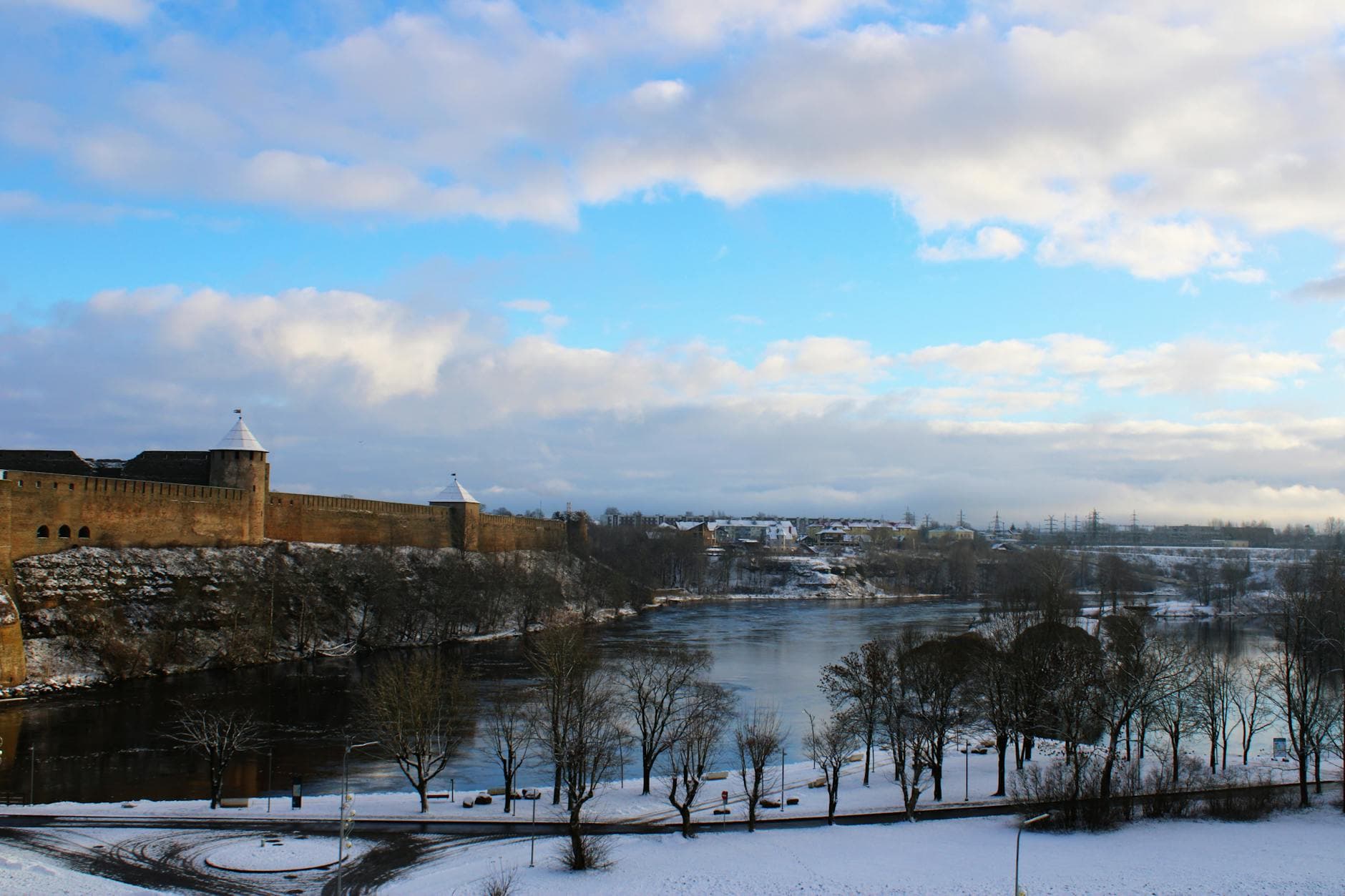 Scenic winter landscape of Narva Castle overlooking the river with snow-covered surroundings in Estonia.