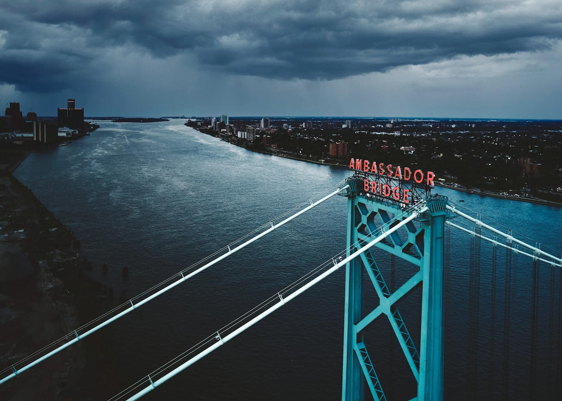 Stunning aerial image of Ambassador Bridge in Detroit under a dramatic sky.