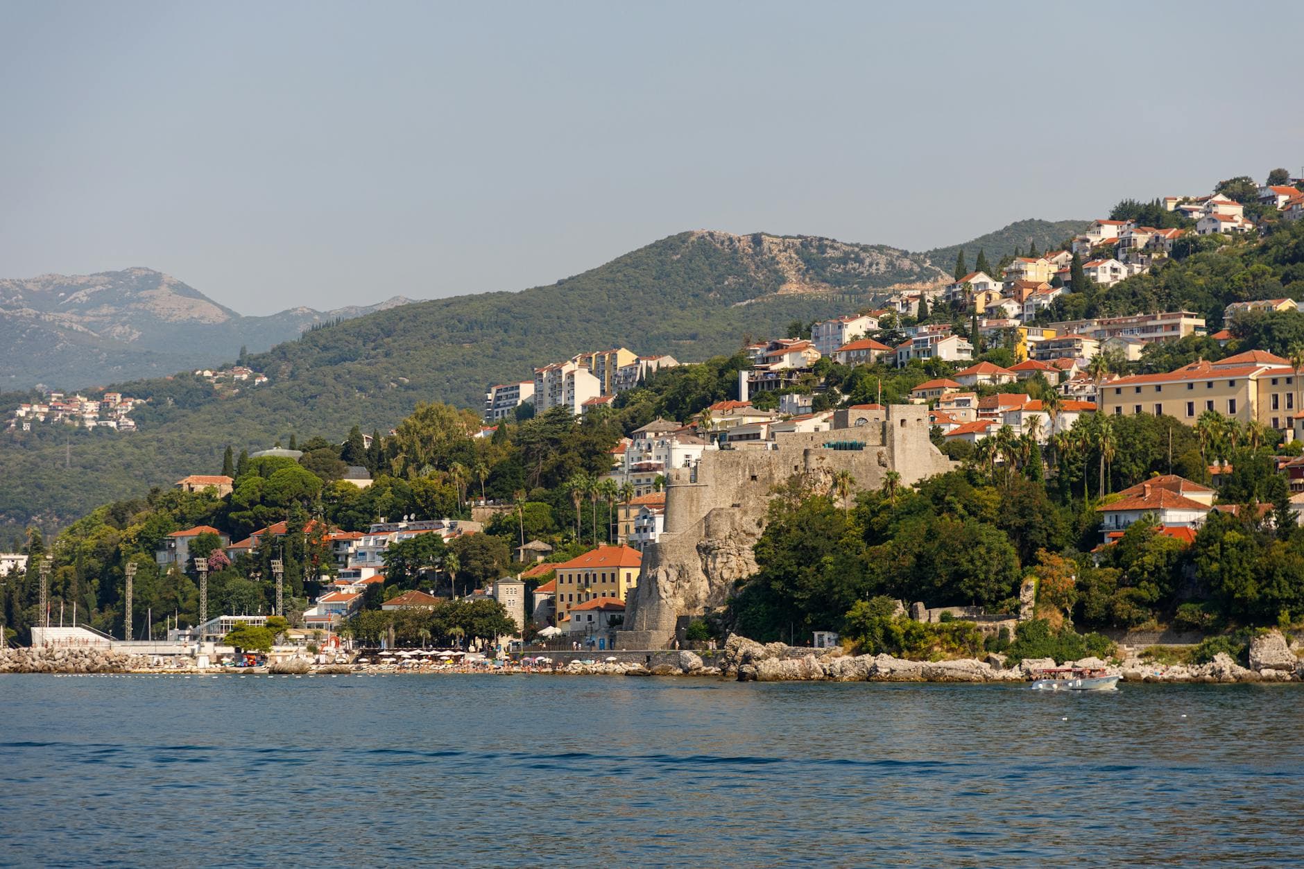 Breathtaking view of the Herceg Novi coastline with historic architecture and lush greenery.