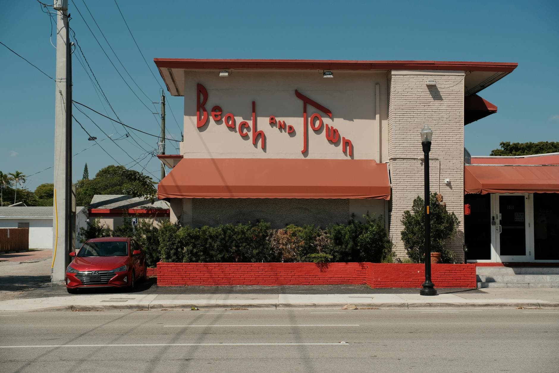 Front view of a retro-style building labeled 'Beach and Town' in sunny Hollywood, Florida.