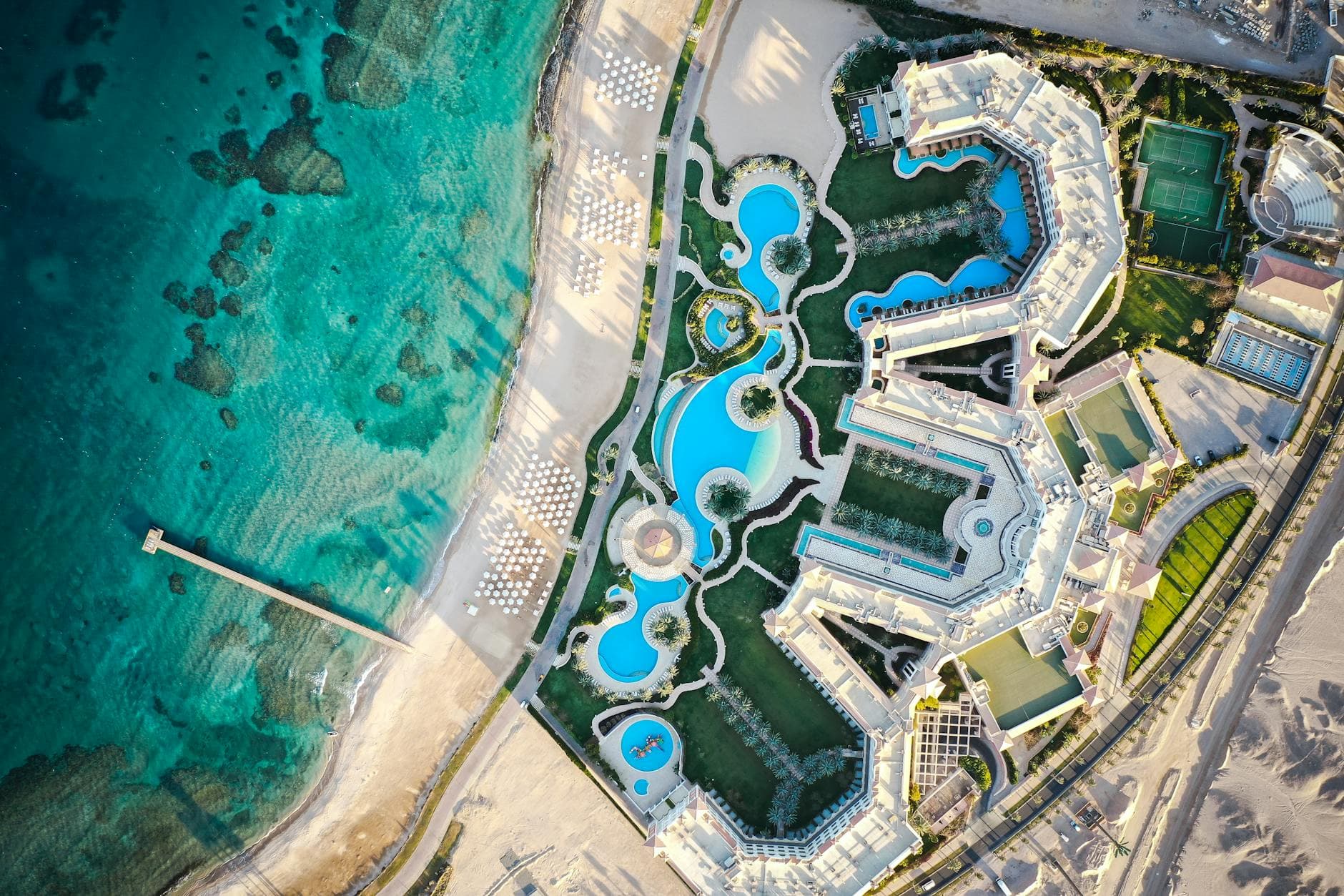 Stunning aerial view of a luxury resort in Hurghada, featuring pools and beach by the Red Sea.