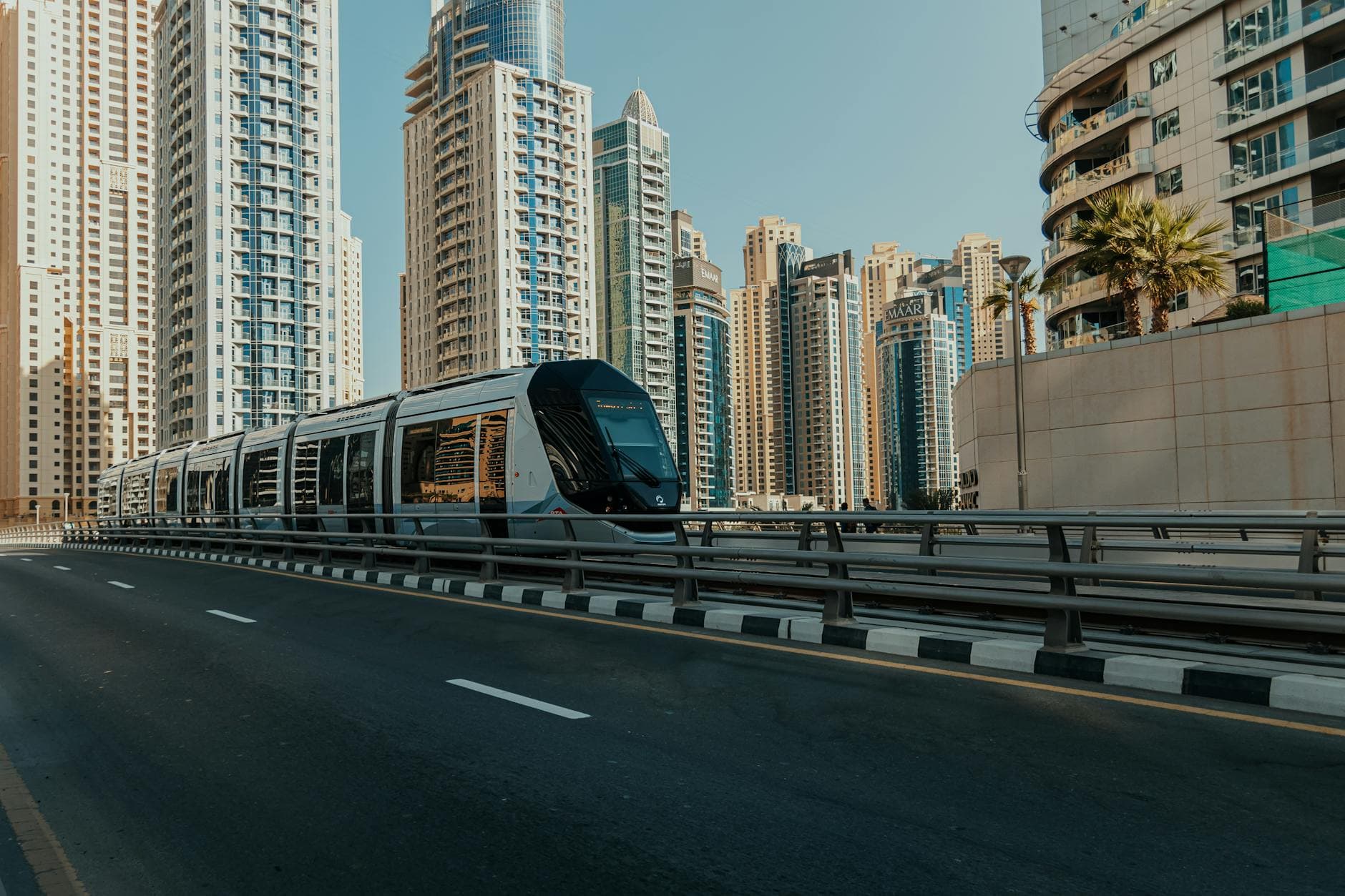 Contemporary tram against the Dubai skyscraper skyline, showcasing urban transportation.