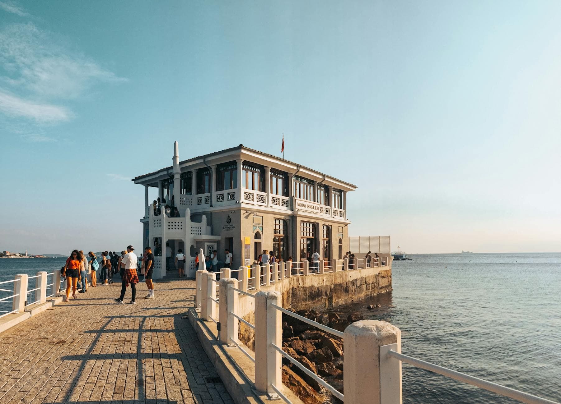 Historic Moda Pier in Kadıköy İstanbul with people enjoying the sunny day by the sea.