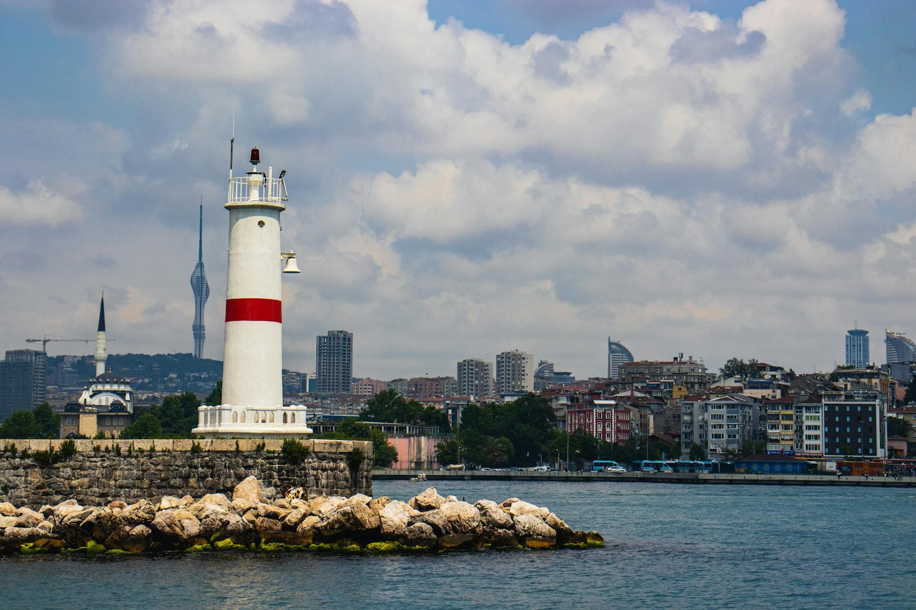 Kadıköy Lighthouse in Istanbul with urban skyline and Bosphorus view.