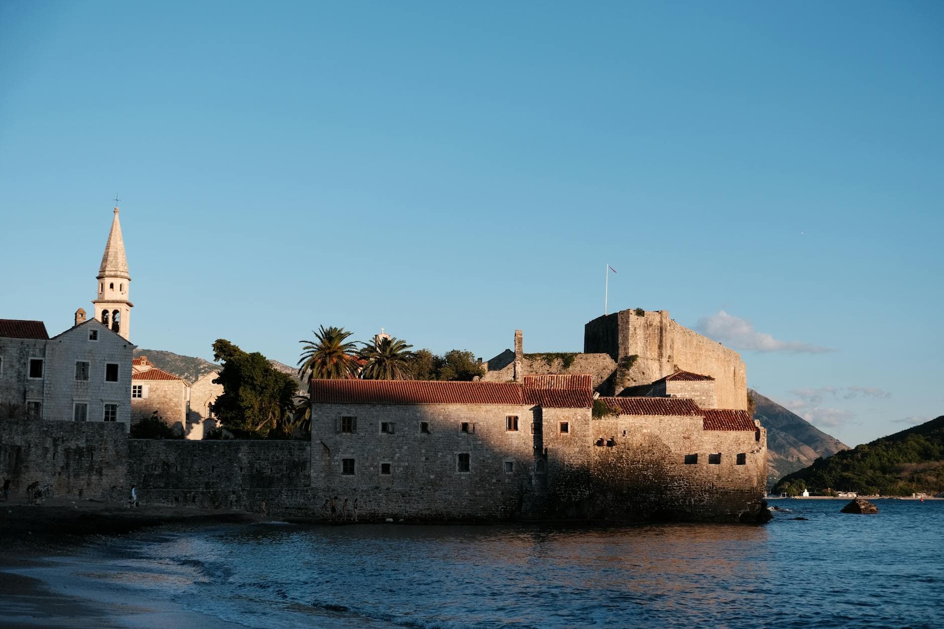 Beautiful sunset over historic Budva Old Town, Montenegro, featuring ancient architecture and coastal landscape.