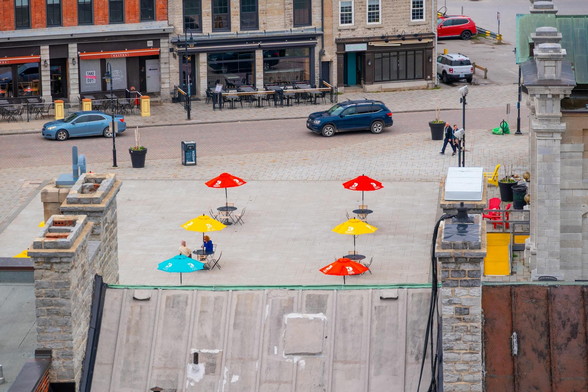 A colorful rooftop patio in Kingston, Ontario offers a vibrant urban scene with umbrellas and street view.