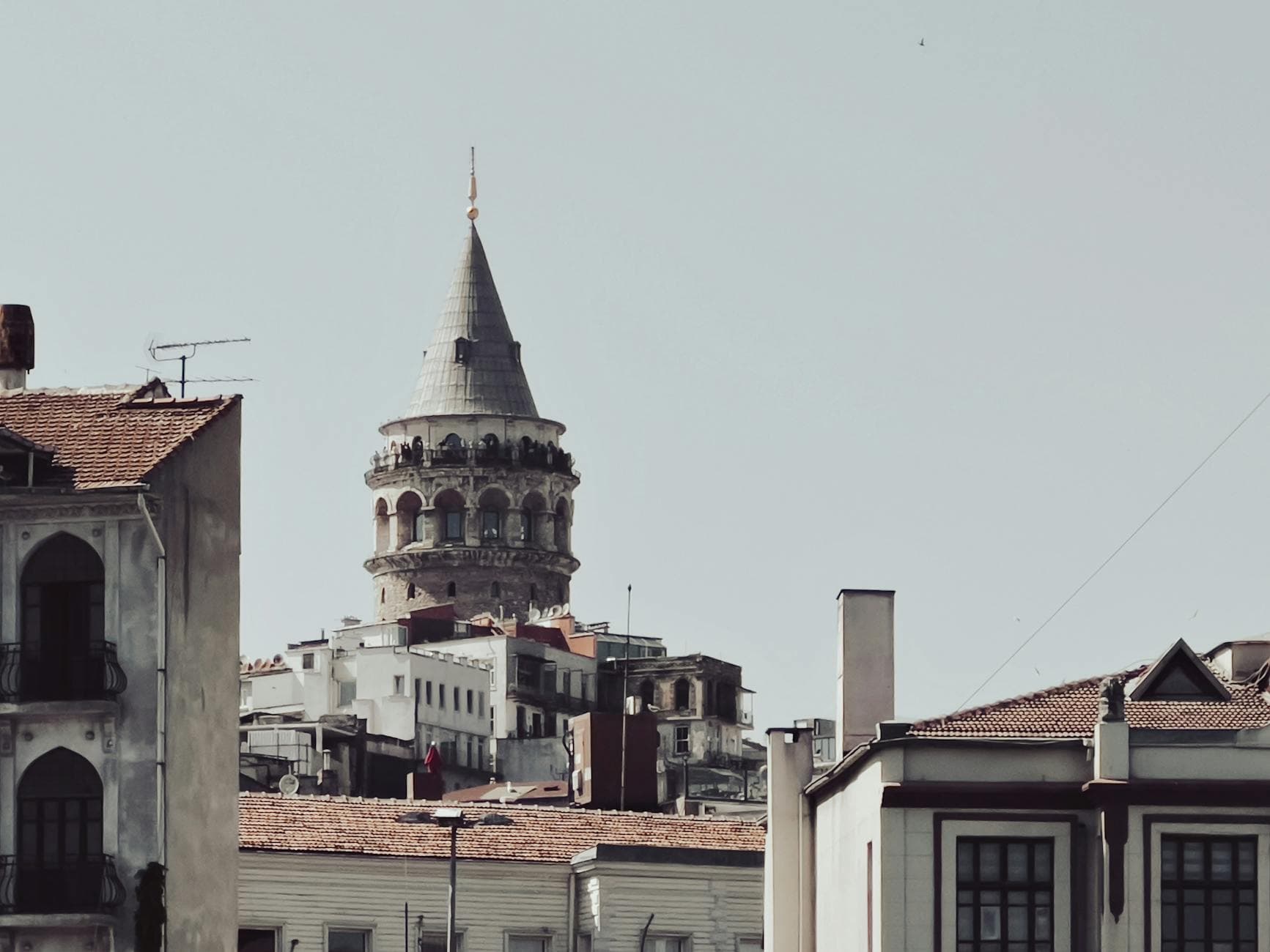 View of the historic Galata Tower rising above buildings in Istanbul, Turkey.