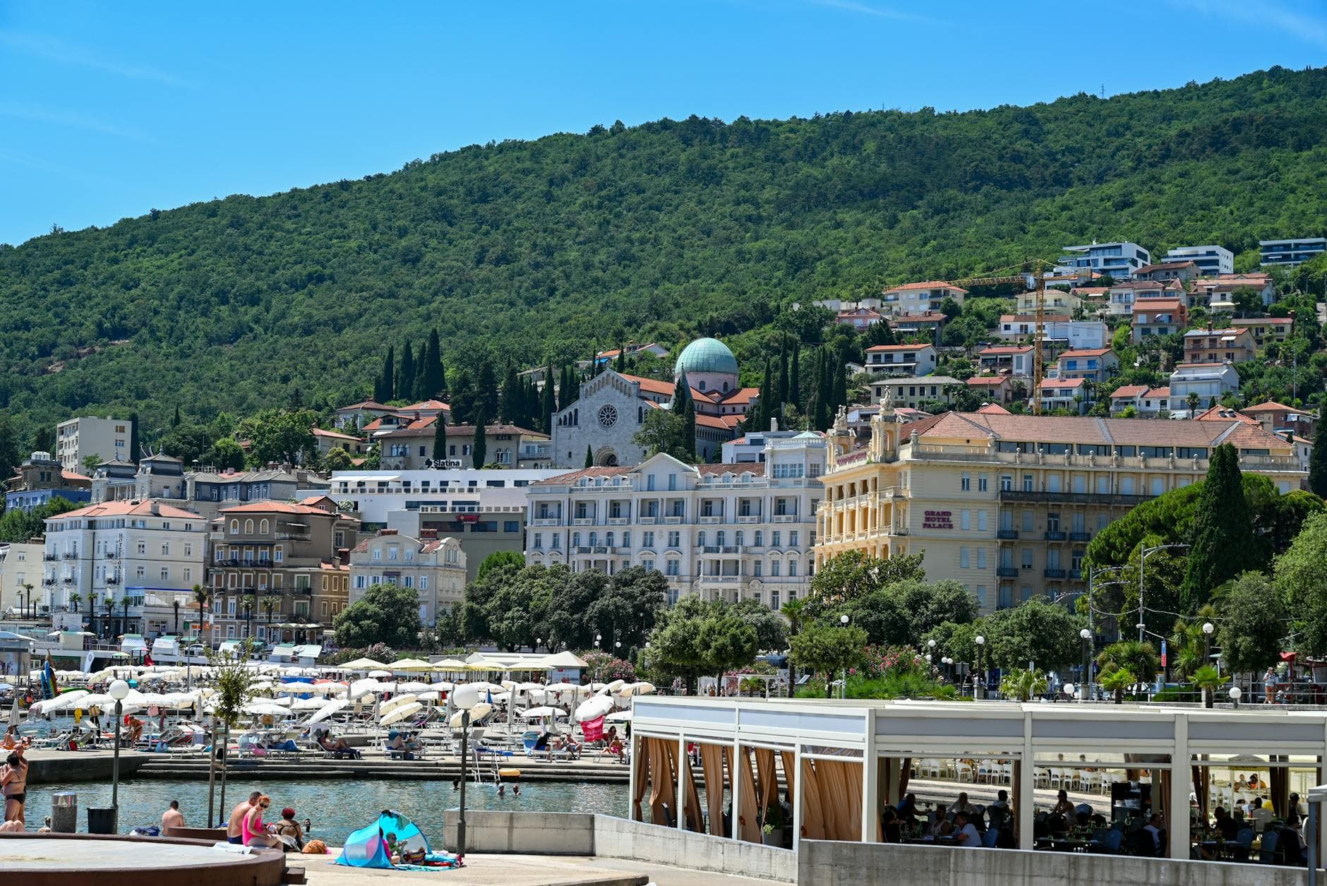 Picturesque seaside view of Opatija, Croatia, showcasing vibrant architecture and lush hills.