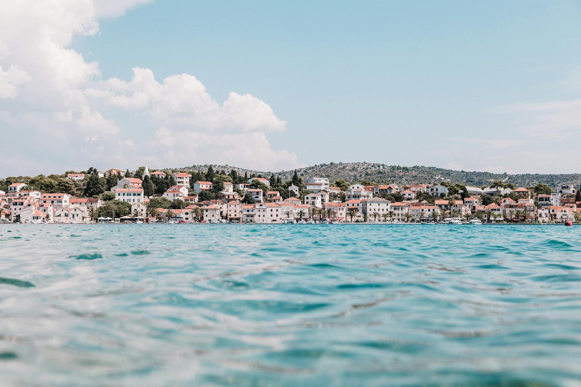 Stunning panoramic view of a coastal town in Croatia, showcasing vibrant rooftops against a calm sea.